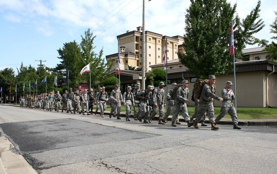 KUNSAN AIR BASE, Republic of Korea -- Members of the Wolf Pack march an American flag on a 10-mile remembrance march here Sept. 11. The flag was carried 10 miles with each mile representing each year since the 9/11 attacks. The flag will be encased in a shadow box and put on display with photos and a plaque, marking the 10-year anniversary. (U.S. Air Force photo/Staff Sgt. Robert Webb)