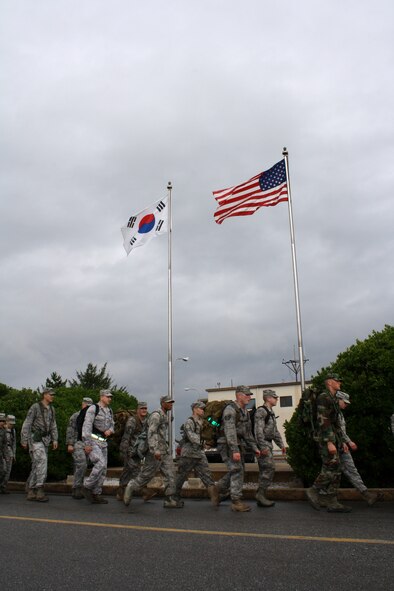 KUNSAN AIR BASE, Republic of Korea -- Members of the Wolf Pack march an American flag on a 10-mile remembrance march here Sept. 11. The flag was carried 10 miles with each mile representing each year since the 9/11 attacks. The flag will be encased in a shadow box and put on display with photos and a plaque, marking the 10-year anniversary. (U.S. Air Force photo/Staff Sgt. Robert Webb)