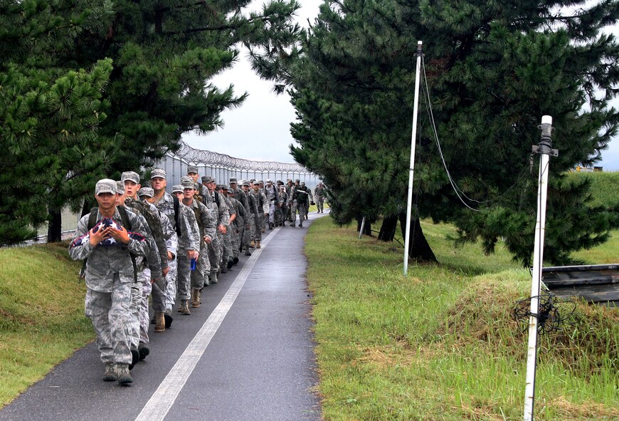 KUNSAN AIR BASE, Republic of Korea -- Members of the Wolf Pack march an American flag on a 10-mile remembrance march here Sept. 11. The flag was carried 10 miles with each mile representing each year since the 9/11 attacks. The flag will be encased in a shadow box and put on display with photos and a plaque, marking the 10-year anniversary. (U.S. Air Force photo/Staff Sgt. Robert Webb)