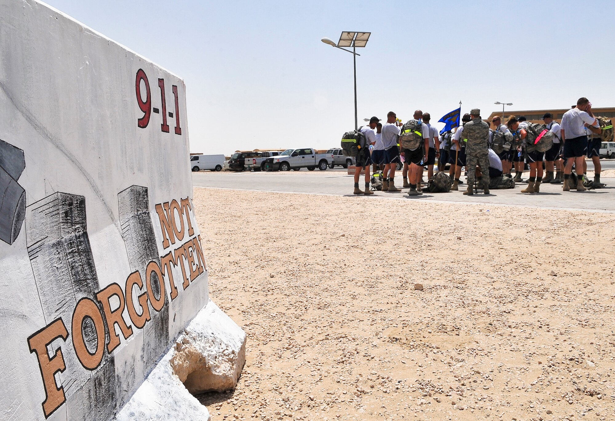 Members of the 379th Expeditionary Security Force Squadron huddle together after completing a 9.11-mile ruck march Sept. 11, 2011, at an undisclosed location in Southwest Asia. The march was one of three base-wide events to commemorate the nearly 3,000 people, including the 55 military members and 411 emergency personnel, who lost their lives 10 years ago in the tragic events of Sept. 11, 2001. (U.S. Air Force photo/Senior Airman Paul Labbe)