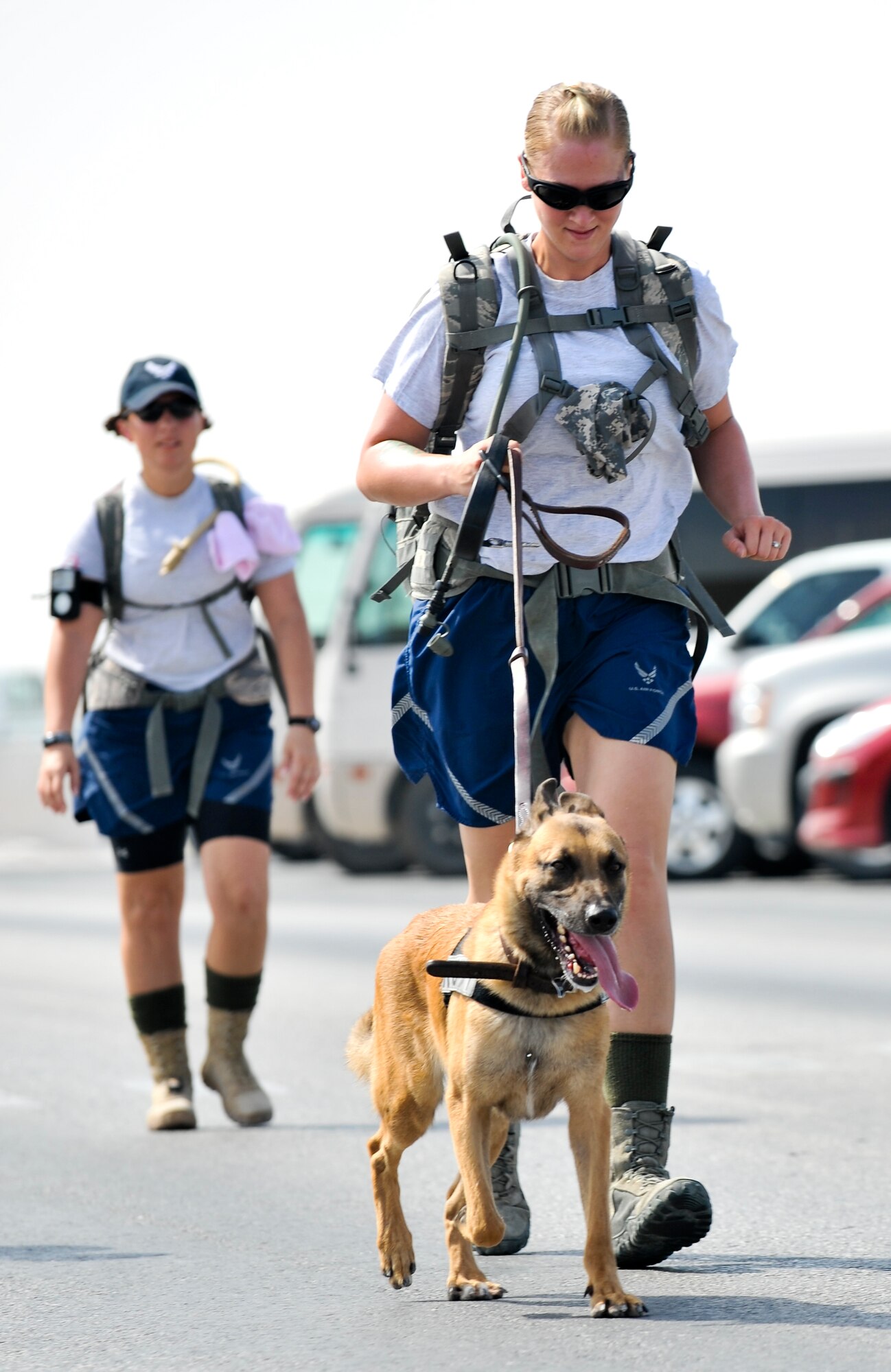 Staff Sgt. Jessica Elias, 379th Expeditionary Security Forces Squadron K-9 handler, runs with her partner Remco, 379th ESFS military working dog, during a 9.11-mile ruck march Sept. 11, 2011, at an undisclosed location in Southwest Asia. Elias, a native of East Moline, Ill., is deployed from Ramstein Air Force Base, Germany. The march was one of three base-wide events to commemorate the nearly 3,000 people, including the 55 military members and 411 emergency personnel, who lost their lives 10 years ago in the tragic events of Sept. 11, 2001. (U.S. Air Force photo/Senior Airman Paul Labbe)