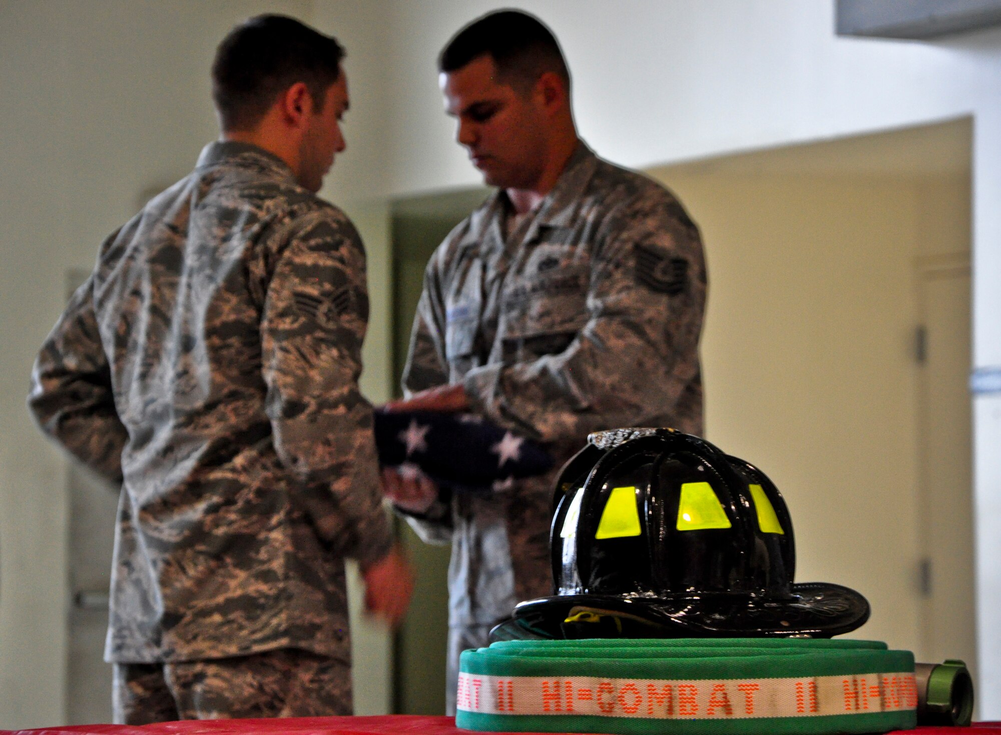 Senior Airman Dustin Boivin and Tech. Sgt. Justin Pederson, both firefighters with the 51st Civil Engineer Squadron, fold a flag Sept. 11, 2011 at Osan Air Base, Republic of Korea. “We will never forget,” is a phrase many Americans have heard thousands of times since Sept. 11, 2001, but for some the words go a bit deeper. The 51st CES fire department held a ceremony to remember and honor the firefighters who lost their lives that fateful day. (U.S. Air Force photo/Tech. Sgt. Chad Thompson)