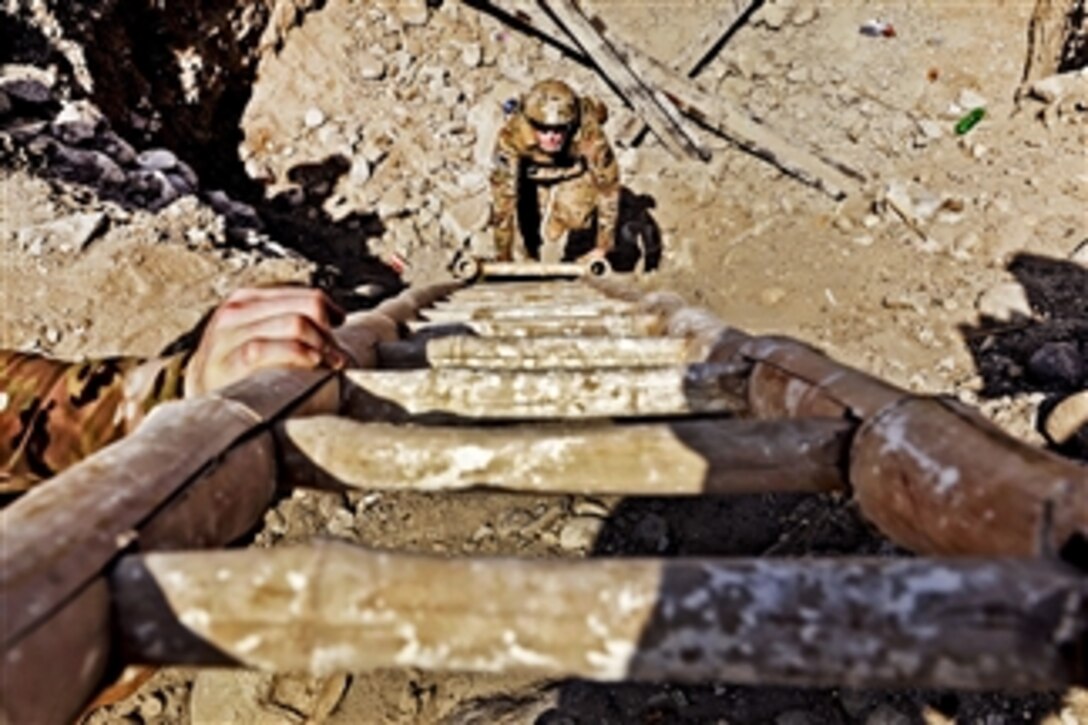 U.S. Army 1st Lt. Scott Adamson climbs up a bamboo ladder after inspecting a project in the Qarghah'i district, Laghman province, Afghanistan, on Sept. 8, 2011.  Adamson is an engineer assigned to the Laghman Provincial Reconstruction Team.  The team's engineers conducted quality assurance checks on three projects and discussed construction plans for a fourth in the district.  