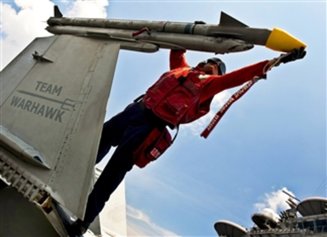 U.S. Navy Petty Officer 2nd Class Stephen Bailey caps a missile attached to an F/A-18C Hornet aboard the aircraft carrier USS John C. Stennis in the South China Sea on Sept. 2, 2011.  