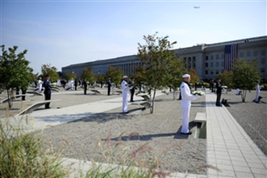 Honor Guard members stand in the memorial courtyard before laying wreaths on each individual bench during the 9/11 remembrance ceremony at the Pentagon Memorial on Sept. 11, 2011.  