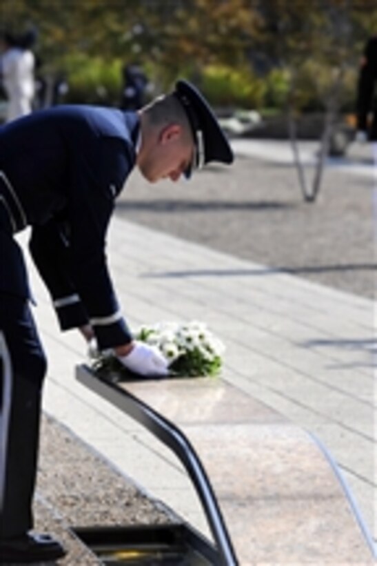 An Air Force Honor Guard member places a wreath on a bench in the Pentagon Memorial during the 9/11 remembrance ceremony on Sept. 11, 2011.  