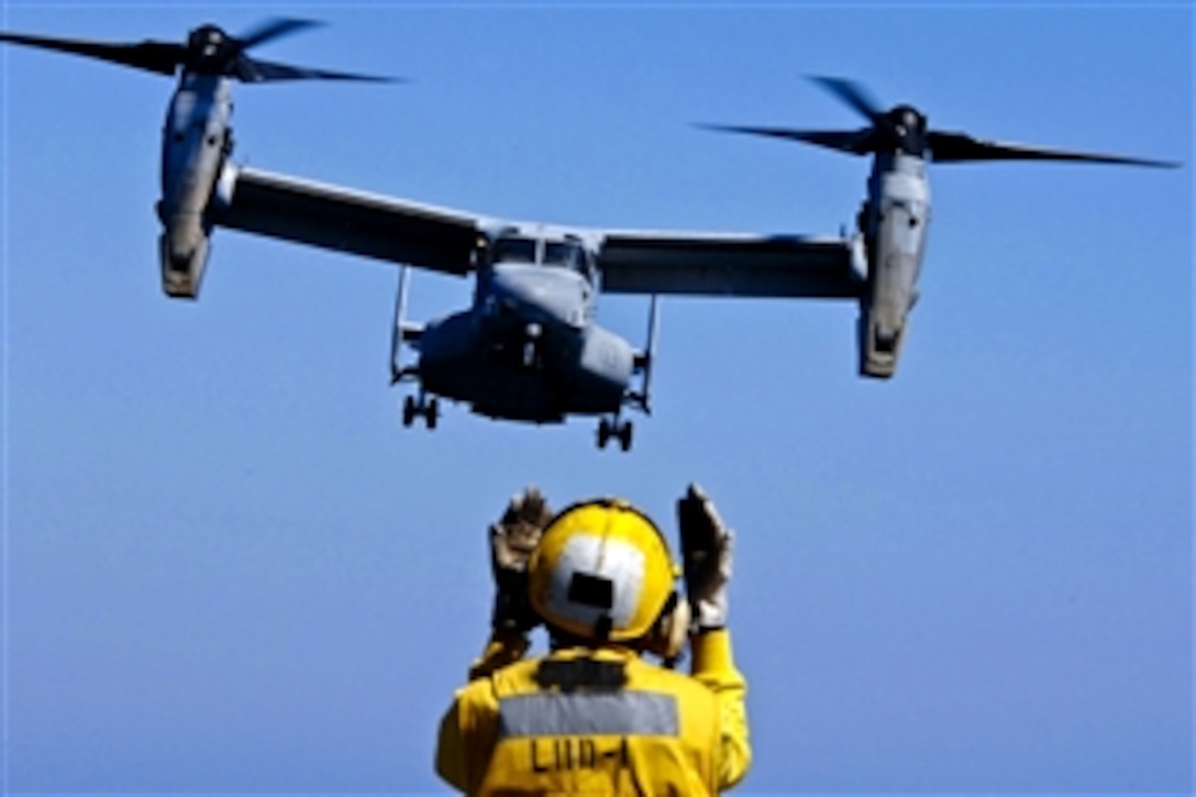 U.S. Navy Petty Officer 3rd Class Eddie Berryhill directs a V-22 Osprey on its final approach aboard the amphibious assault ship USS Wasp in the Atlantic Ocean, Sept. 9, 2011. The Wasp is conducting sea trials. Berryhill is an aviation boatswain's mate.