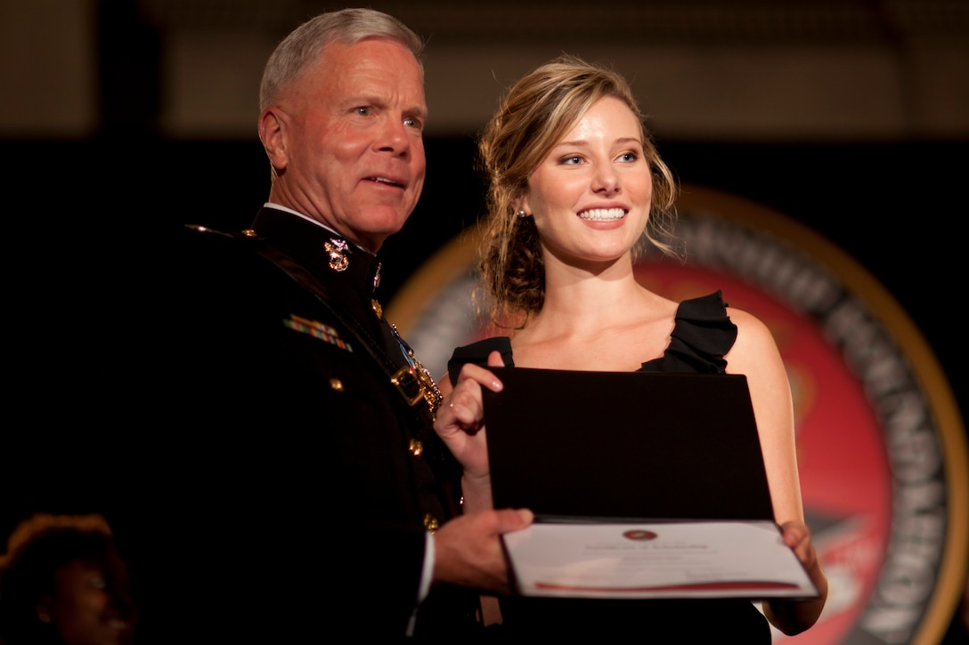 Alison Spann, a sophomore at Pepperdine University, receives the Hero Tribute Scholarship from Gen. James F. Amos, commandant of the Marine Corps, at the 2011 Scholarship Announcement Ceremony and Reception at the Library of Congress Sept. 13, 2011. Spann’s father, Marine veteran Johnny Michael Spann, was the first American killed in combat after Sept. 11, 2001.::r::::n::