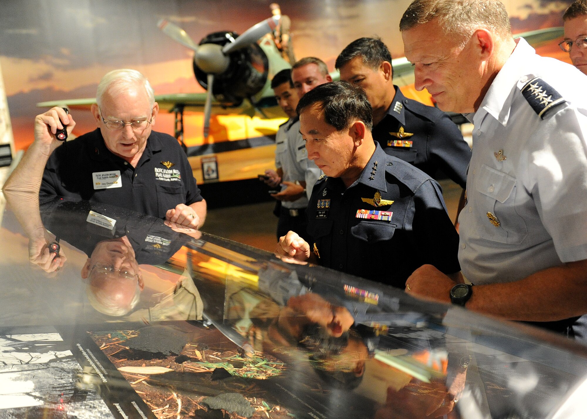 Jay Dunn (left), Pacific Aviation Museum tour guide, explains an exhibit to Air Chief Marshal Itthaporn Subhawong, Commander-in-Chief of the Royal Thai Air Force, and General Gary North, Pacific Air Forces commander, at the Pacific Aviation Museum, Ford Island, Hawaii, Sept. 8.  Air Chief Marshal Itthaporn visited Hawaii to meet with General North and senior leaders of PACAF to discuss common concerns and explore opportunities to strengthen regional cooperation. (U.S. Air Force photo/Tech. Sgt. Jerome S. Tayborn (Released))