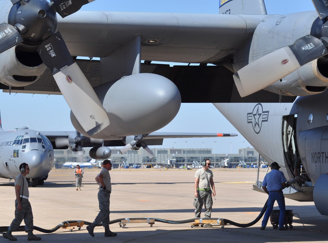 Air National Guard Airmen deployed from the North Carolina Air National Guard work to refill a Modular Airborne Firefighting System-equipped C-130 Hercules Sept. 13 Austin-Bergstrom International Airport in Austin, Texas while another aircraft prepares to taxi for takeoff to a fire. Assigned to the 302nd Air Expeditionary Group, the Airmen worked to launch aerial firefighting aircraft in support of a 1,400-acre fire 25 miles east of College Station, Texas. (U.S. Air Force photo/Staff Sgt. Stephen J. Collier)