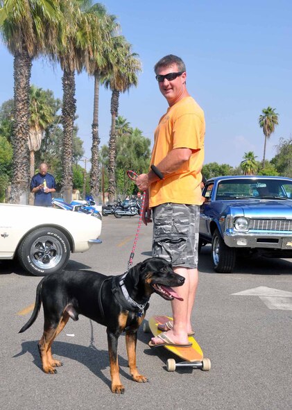 Master Sgt. Dave Hoopes, 452nd Aircraft Maintenance Squadron and his Rottweiler Lab mix, Digger, 2, enjoy the sunshine, at the 39th Annual Military Appreciation Picnic at March Air Reserve Base, Calif., Sept. 10, 2011.  Digger has his own long board that he knows how to use at home.  (U.S. Air Force photo/Master Sgt. Linda Welz)