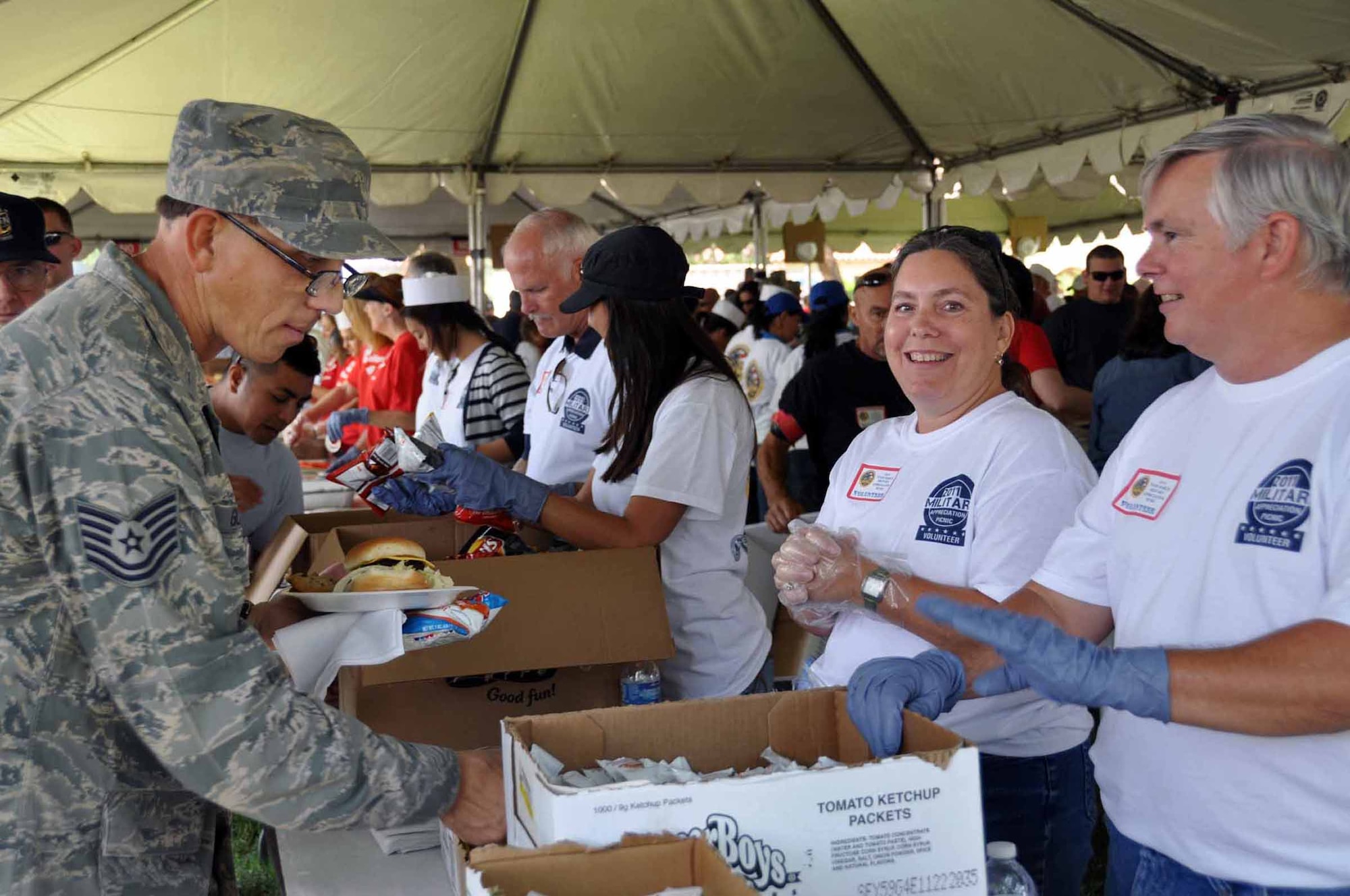 Riverside volunteers Roger and Karen McCoy serve food to Staff Sgt. Gary Glaze, 452nd Civil Engineering Squadron, at the 39th Annual Military Appreciation Picnic at March Air Reserve Base, Calif., Sept. 10, 2011.  The ?picnic is held each year during the combined unit training assembly weekend.  (U.S. Air Force photo/ Master Sgt. Linda Welz)