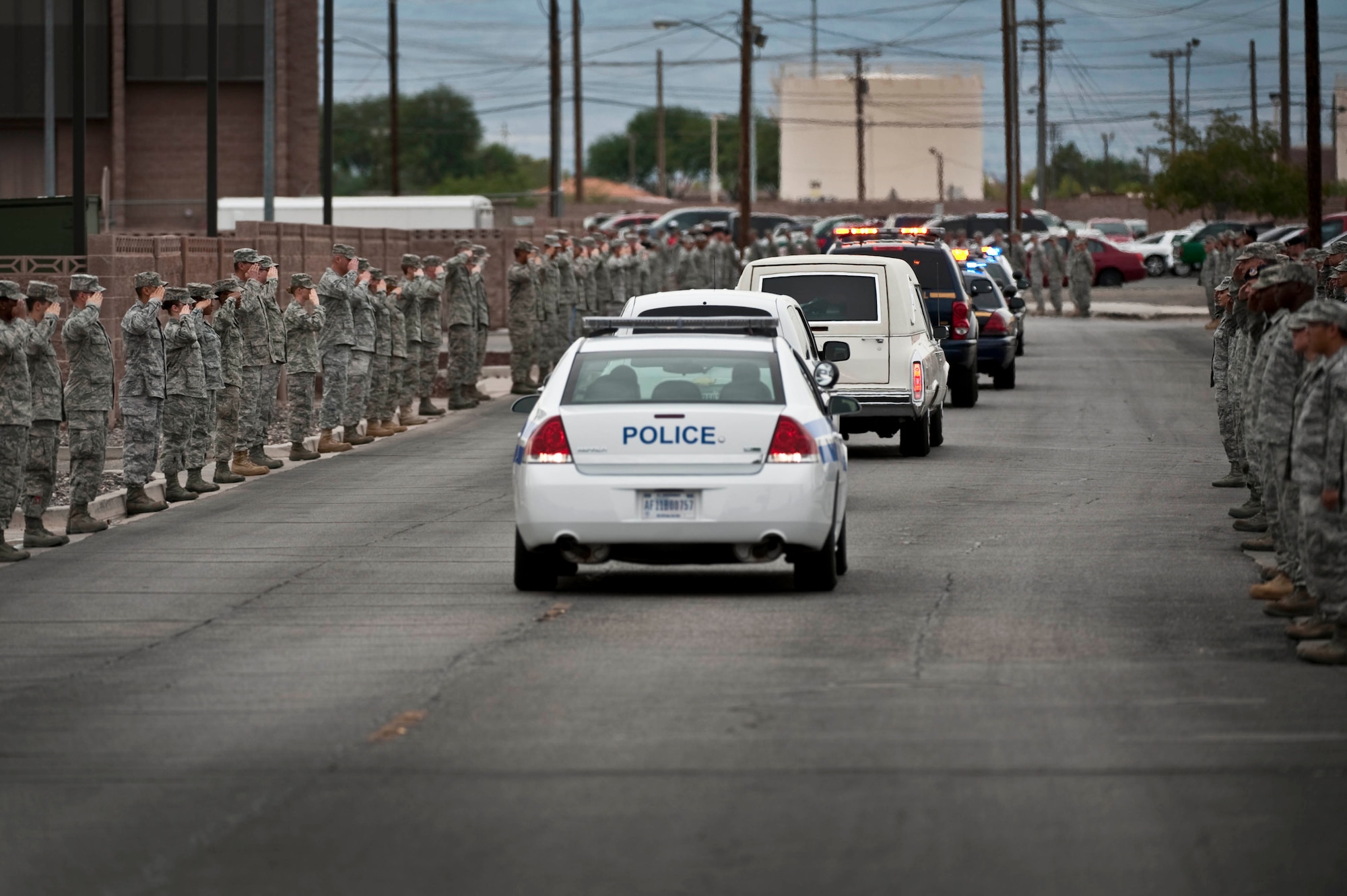 Airmen line the streets of Nellis Air Force Base, Nev., to pay their respects as a hearse carrying U.S. Army Spc. Dennis James Jr., a soldier deployed to Afghanistan from the 10th Mountain Division at Fort Polk, La. was killed by an improvised explosive device, Aug. 31, 2011. James will be entered into the Southern Nevada Veteran Memorial Cemetery Sept. 26, 2011 at Boulder City, Nev.(U.S. Air Force photo by Tech. Sgt. Michael R. Holzworth/Released)
