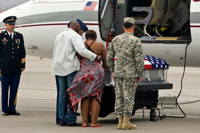 Rhonda and Aaron Williams, aunt and uncle of U.S. Army Spc. Dennis James Jr., take a moment to grieve during a dignified transfer ceremony for their nephew at Nellis Air Force Base Nev., Sept. 13, 2011. James was deployed to Afghanistan from the 10th Mountain Division at Fort Polk, La. when he was killed by an improvised explosive device, Aug. 31, 2011. James will be entered into the Southern Nevada Veteran Memorial Cemetery Sept. 26, 2011 at Boulder City, Nev.(U.S. Air Force photo by Airman 1st Class Matthew Lancaster/Released)