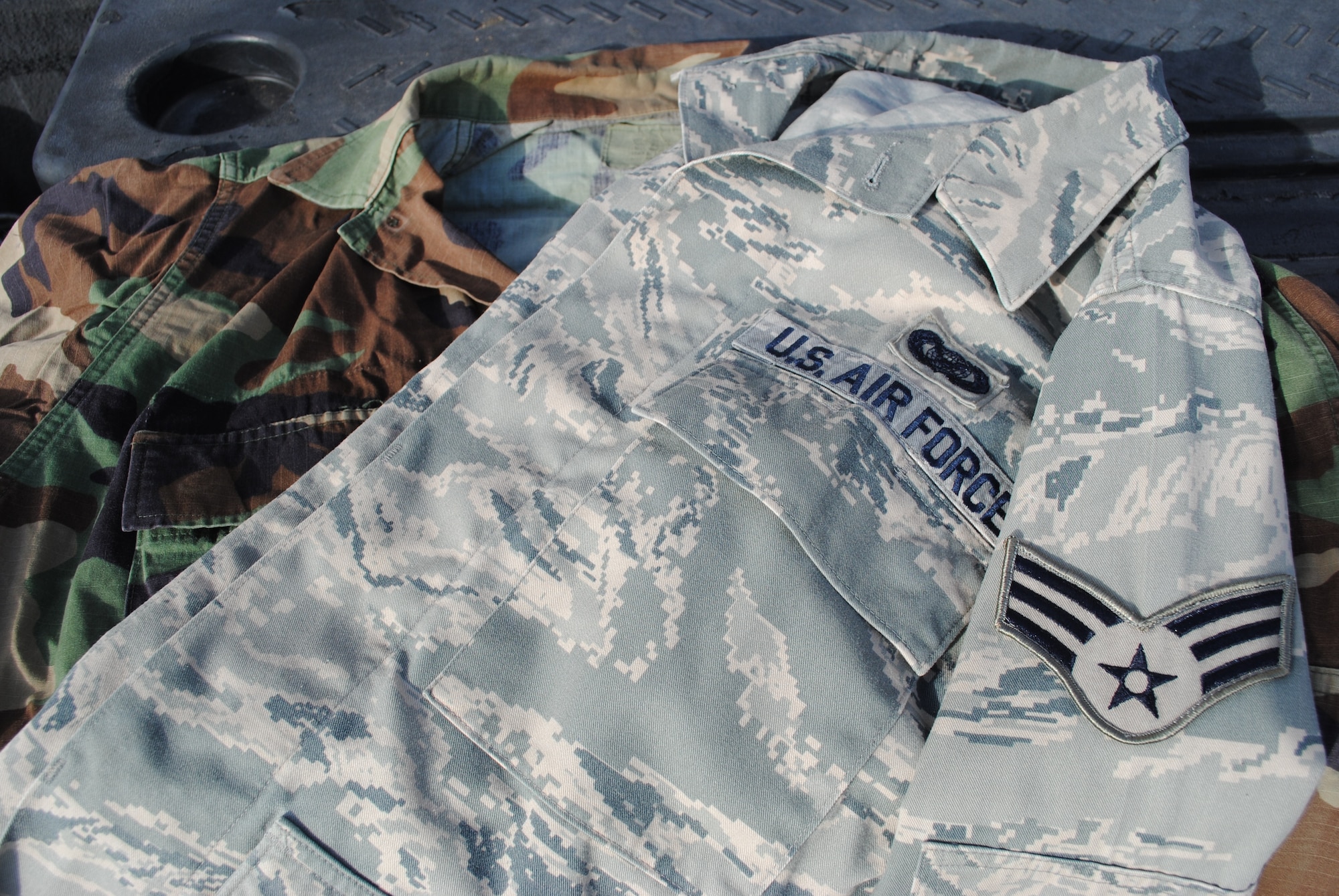 A men's Airman Battle Dress Uniform shirt lays above a Battle Dress Uniform shirt Sept. 14, 2011, at Lackland Air Force Base. The BDU is scheduled to be phased out Nov. 1, 2011. The ABU will replace the BDU as the primary utility uniform in the U.S. Air Force. (U.S. Air Force photo/Senior Airman Luis Loza Gutierrez)