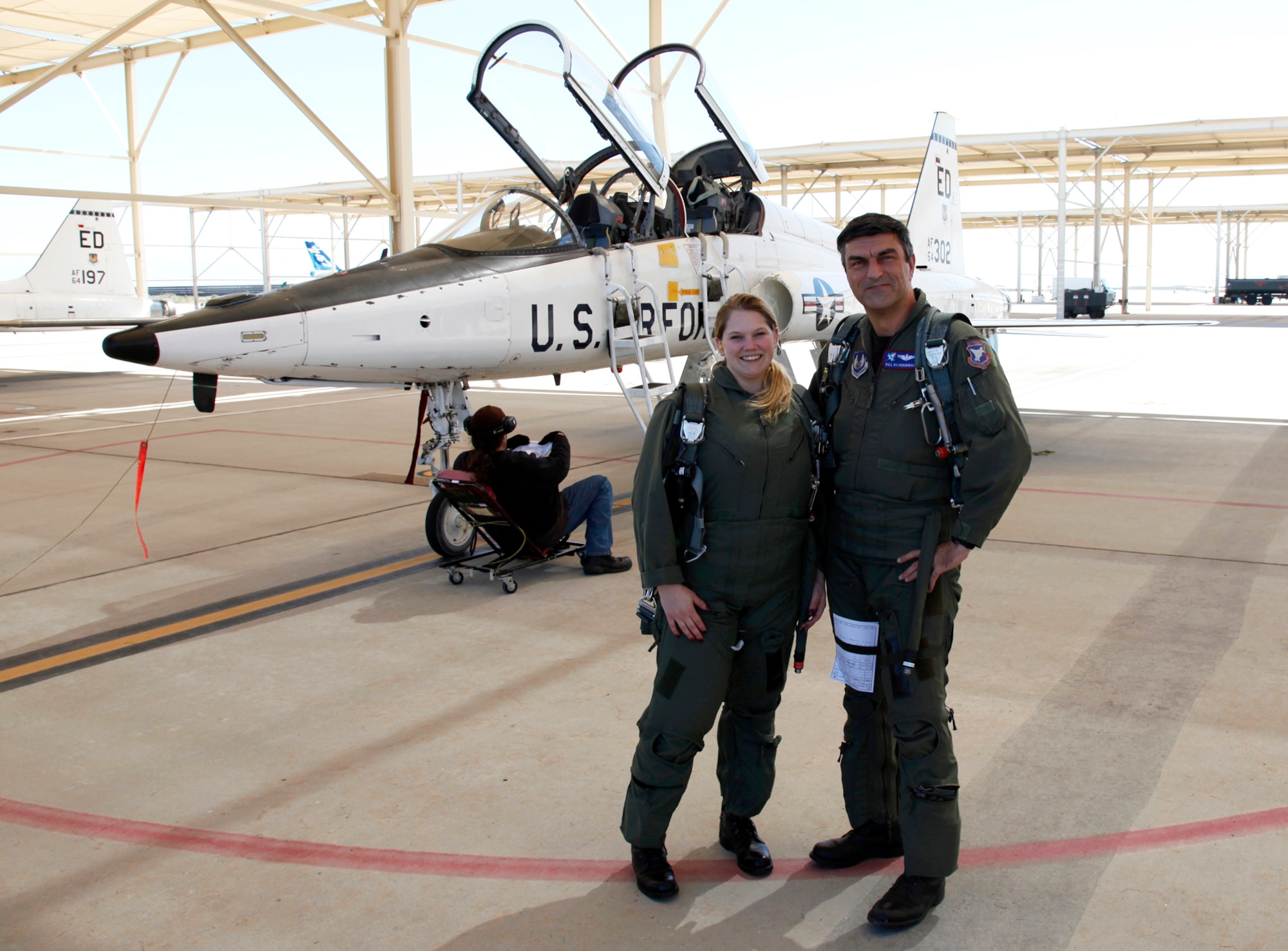 Bill Koukourikos, Air Force Flight Test Center Flight Safety deputy chief, and Laura Mowry, 95th Air Base Wing Public Affairs specialist, pose for a photo before boarding their T-38 Supersonic Trainer. Mowry was rewarded with the opportunity to accompany a pilot on a proficiency flight because she won the Air Force Flight Test Center Student of the Year Award.  (Air Force photo by Christian Turner)