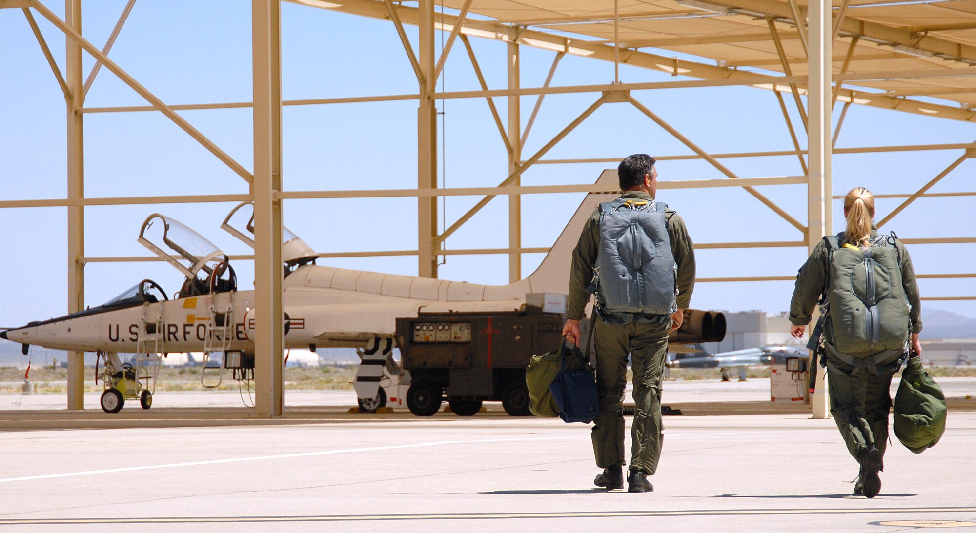 Bill Koukourikos, Air Force Flight Test Center Flight Safety deputy chief, and Laura Mowry, 95th Air Base Wing Public Affairs specialist, walk to their T-38 Supersonic Trainer. Mowry was rewarded with the opportunity to accompany a pilot on a proficiency flight because she won the Air Force Flight Test Center Student of the Year Award.   (Air Force photo by Jet Fabara)