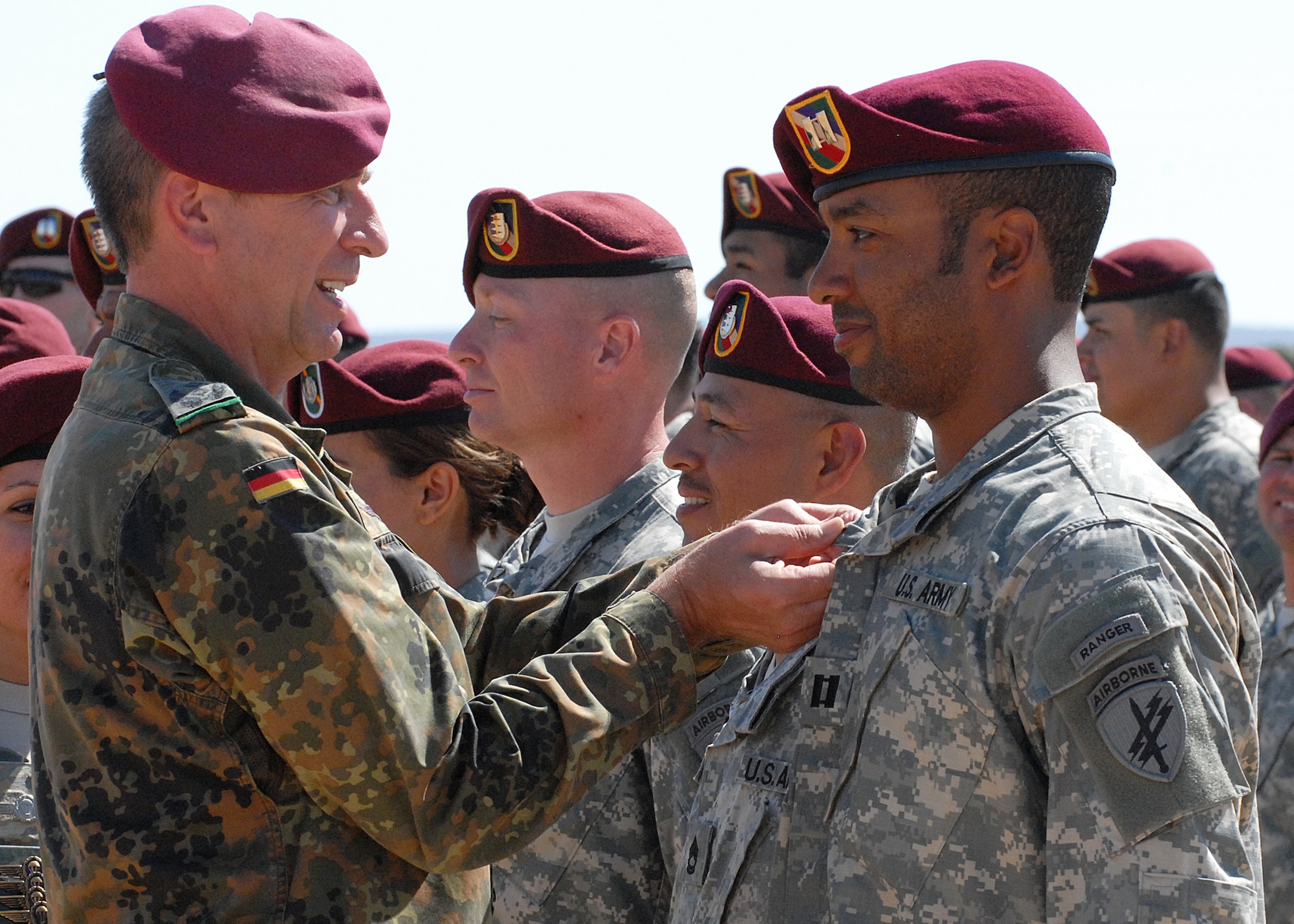 Lt. Col. Chris Bocker of the German Armed Forces pins the German Parachutist Badge on an Army captain during Sept. 11 jump at Edwards.  The paratroopers received their jump commands from German jumpmasters, allowing them to earn the German wings.  Soldiers from California’s 426th Civil Affairs Battalion along with two Texas units, the 344th Psychological Operations Company from Austin and the 345th PYSOP Company from Dallas, participated in the event. (Air Force photos by Kenji Thuloweit)