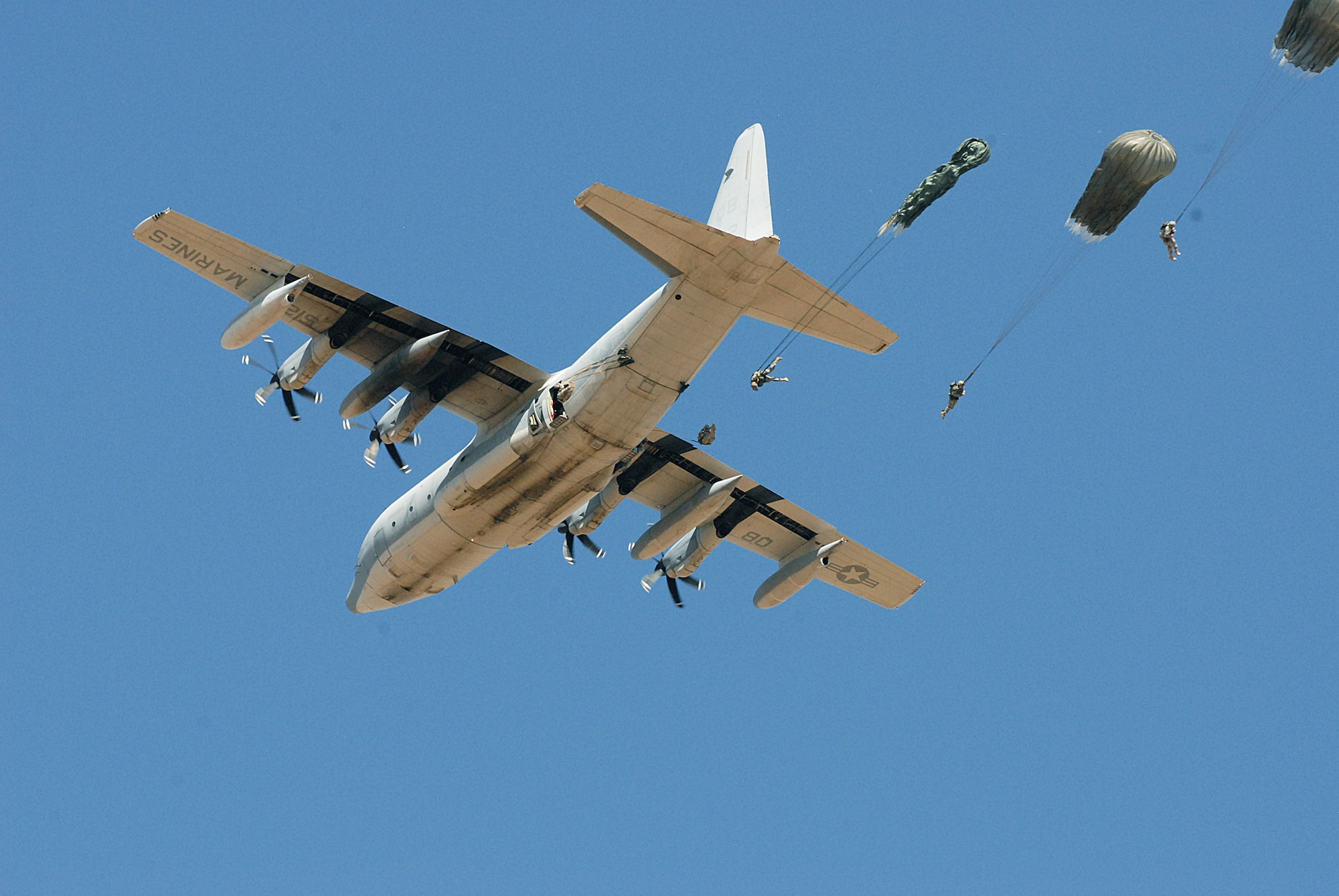 A Marine Corps KC-130 from the 3rd Marine Aircraft Wing stationed at Marine Corps Air Station Miramar, Calif., drops Army paratroopers over Edwards Air Force Base’s Farm Drop Zone Sept. 11.  Nearly 150 Soldiers from three Army Reserve units performed their proficiency jumps as part of a 9/11 commemorative event put on by California’s 426th Civil Affairs Battalion and the Association of the United States Army Inland Empire Chapter.  (Air Force photo by Kenji Thuloweit)