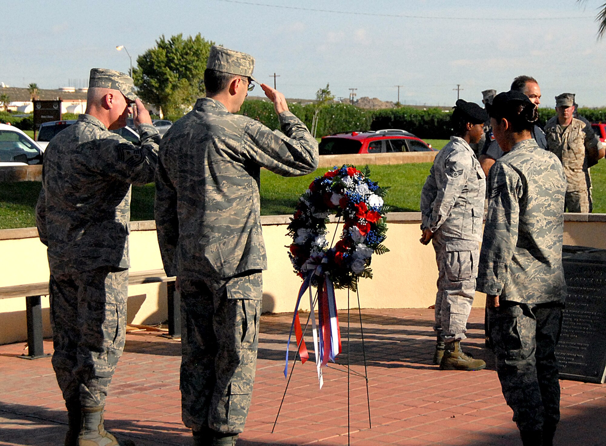 Chief Master Sgt. Bill Thomaston (left), 95th Air Base Wing command chief, and Col. Gregory Schwab, 95th ABW commander, salute a wreath they placed during the base’s ceremony commemorating the 10th anniversary of the 9/11 attacks. (Air Force photo by Diane Betzler)