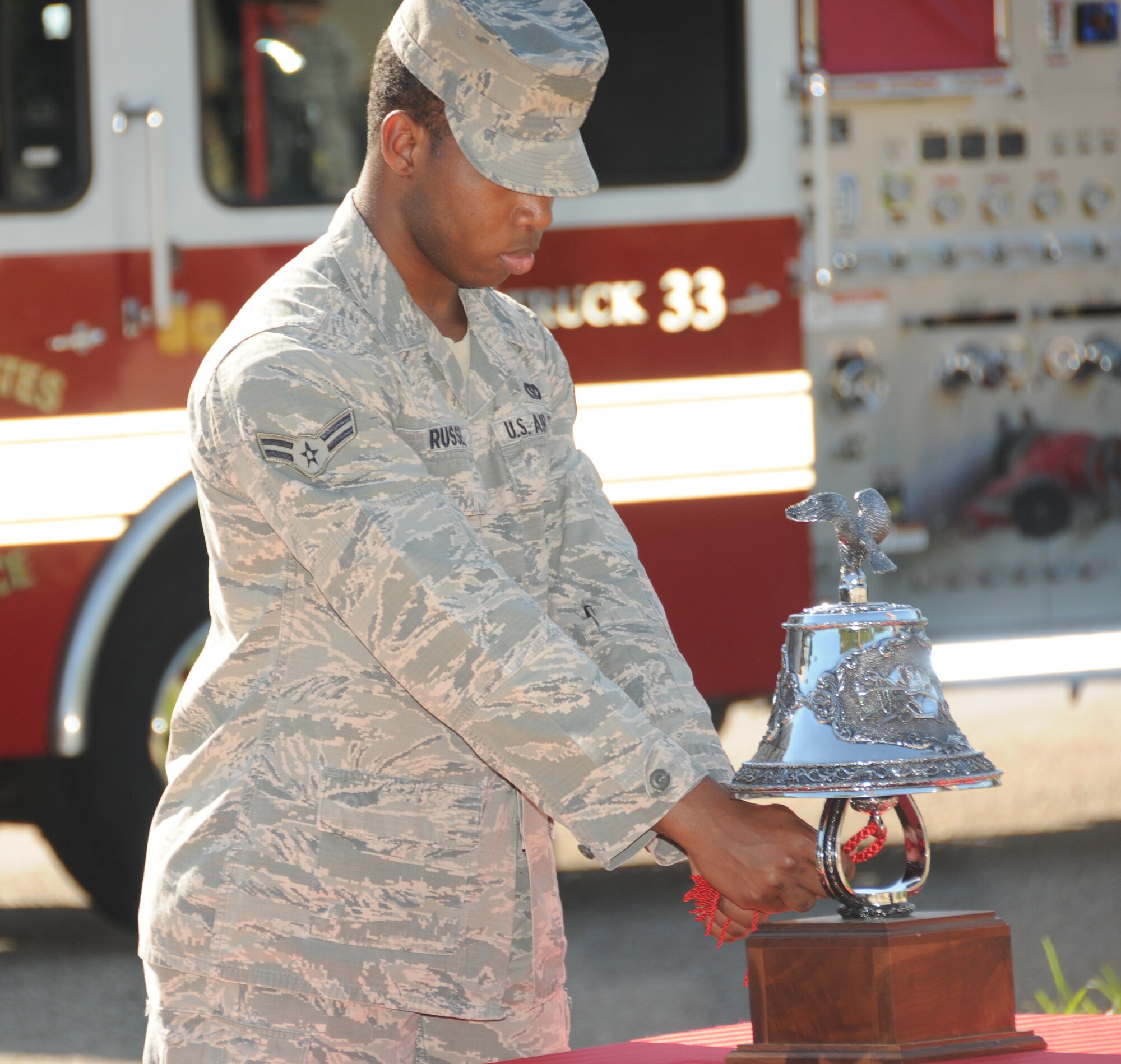 Airman 1st Class Kyeonee Russell, a Keesler firefighter, tolls the bell for “last alarm” in
memory of the firefighters that lost their lives in the terrorist attacks on Sept. 11, 2001,
during formal retreat Sept. 9, in front of 81st Training Wing headquarters.  (U.S. Air Force photo by Kemberly Groue)