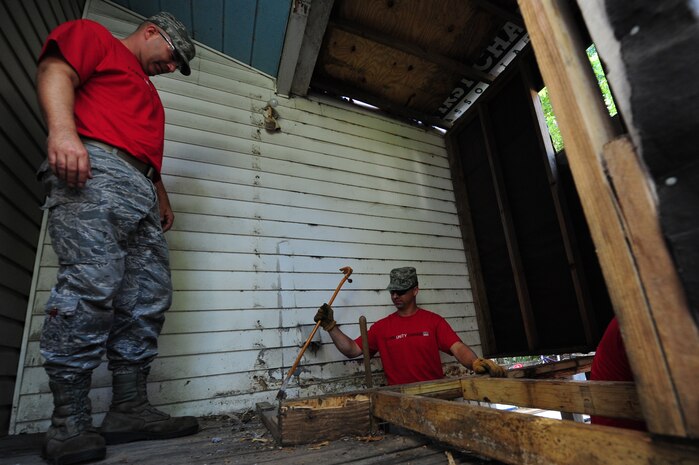 Staff Sgt. Justin Diggins looks on as Staff Sgt. John Roberts pulls up old floor boards from a deck during National Day of Caring, Sept. 9, 2011, in the East Central neighborhood of Charleston, S.C.  More than 200 volunteers participated in 35 projects which included landscaping, debris removal, painting, and light repairs in neighborhoods located in downtown Charleston. Military, DoD civilians, dependents and retirees participated in the community service project. Diggins is a hydraulic mechanic with the 315th Maintenance Squadron and Roberts is with the 437th Maintenance Squadron. (U.S. Air Force photo/Staff Sgt. Nicole Mickle)