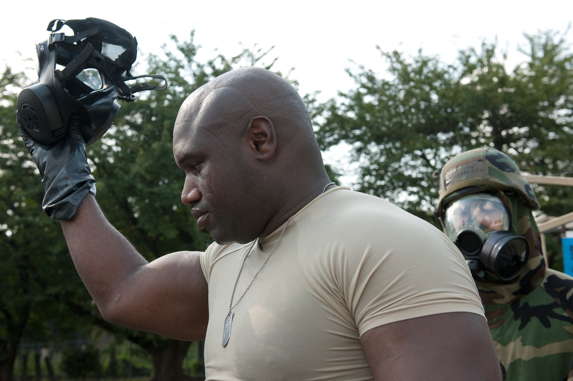YOKOTA AIR BASE, Japan -- Master Sgt. Jerome Fuller, 374th Dental Squadron, removes his gas mask after completion of a chemical decontamination procedure at Yokota Air Base, Japan, Sept. 14, 2011 during a wing readiness exercise. (U.S. Air Force photo/Osakabe Yasuo) 