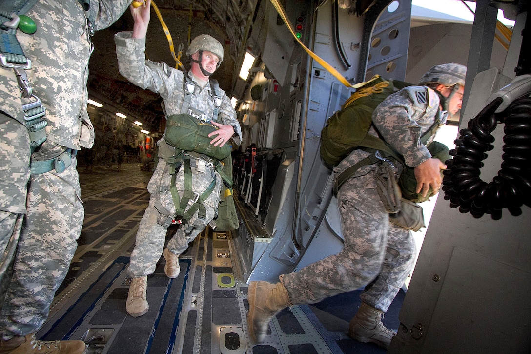 Army paratroopers jump from a C-17 Globemaster III aircraft during an airborne training exercise on Fort Bragg, N.C., Sept. 10, 2011. The yellow cord, called a static line, deploys the paratroopers parachute automatically once they leave the plane.