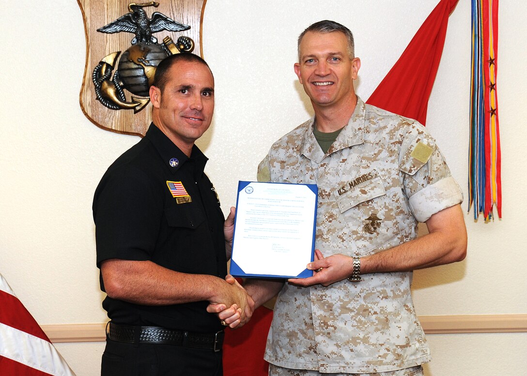 Assistant Fire Chief Paul Purdy (left), Marine Corps Fire Department, Marine Corps Logistics Base Barstow, accepts his DoD award for Fire Officer of the Year for 2010 during the Base Quarterly Wards ceremony Sept 14, 2011, at the Maj. Gen. James L. Day Conference Center.