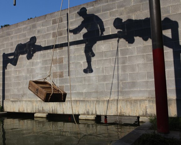 A fire team of Marines with Charlie Company, 1st Battalion, 2nd Marine Regiment, climb across a beam above three-feet of water during a training exercise at the Leadership Reaction Course on Fort Pickett, Va., Sept. 14, 2011. More than 900 Marines and sailors are taking part in the Deployment for Training exercise at Fort Pickett, Sept. 6-23. The battalion is scheduled to attach to the 24th Marine Expeditionary Unit as its Battalion Landing Team a few days after the training.