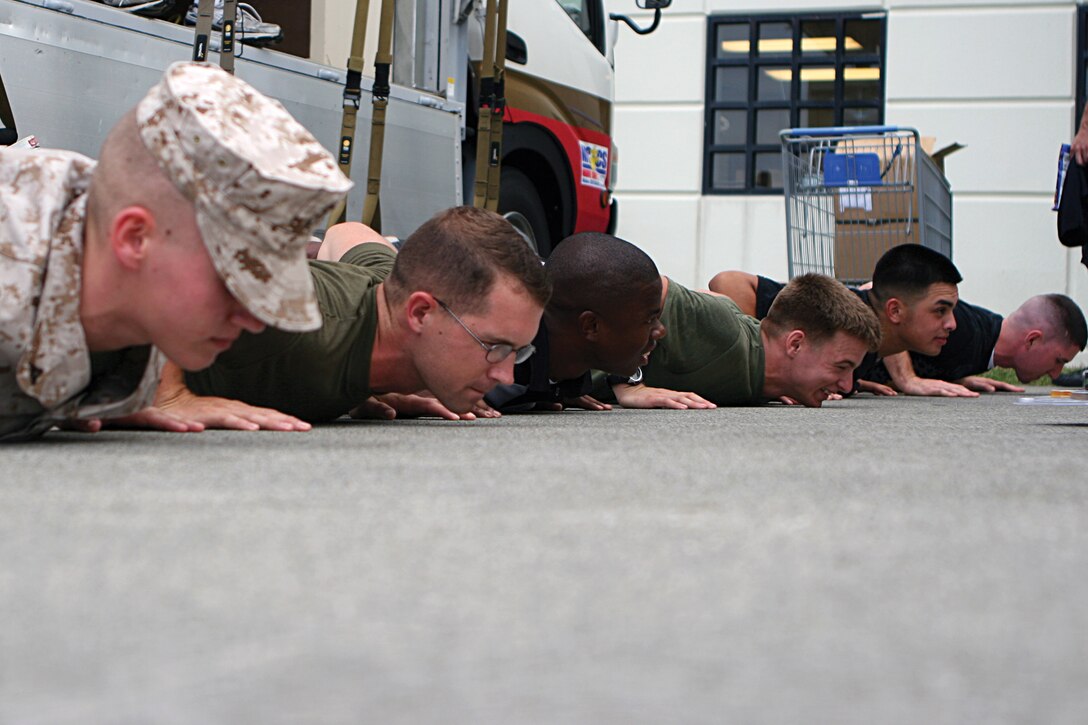 Marines and sailors perform push-ups during the Commissary Commando competition held at the Camp Foster Commissary Sept. 15. The Single Marine Program holds this event annually to show single service members the benefits of shopping at the commissary.