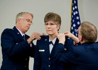 Newly promoted Col. (Dr.) Meredith Goodwin, the chief of aerospace medicine for the 919th Medical Squadron, gets her eagles pinned on Sept. 11 at Duke Field, Fla. Doing the honors are Lt. Col. (Dr.) Gregory Candell, left, the squadron's assistant chief of aerospace medicine, and Col. (Dr.) Edward Seeliger, commander of the 919th MDS.  (U.S. Air Force photo/Tech. Sgt. Samuel King Jr.)