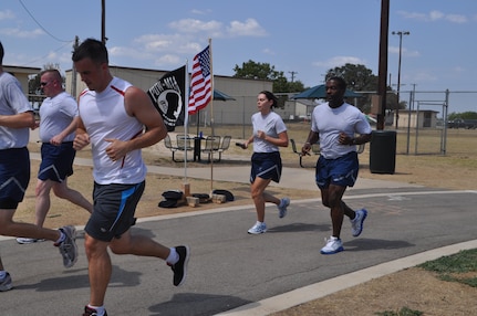 Members of the 33rd Network Warfare Squadron and the 26th Network Operations Group kept the baton moving for their part of the 24-hour POW/MIA Vigil Run at the Gillum Fitness Center track, Lackland Air Force Base, Texas, Sept. 15. Volunteers also read aloud the names of American military members listed as prisoners of war or missing in action. Other 24th Air Force units that took part in the run included Headquarters 24th Air Force, the 346th Training Squadron, the 624th Operations Center, the 90th Information Operations Squadron, and the 690th Information Operations Squadron. (U.S. Air Force photo by Tech. Sgt. Scott McNabb)
