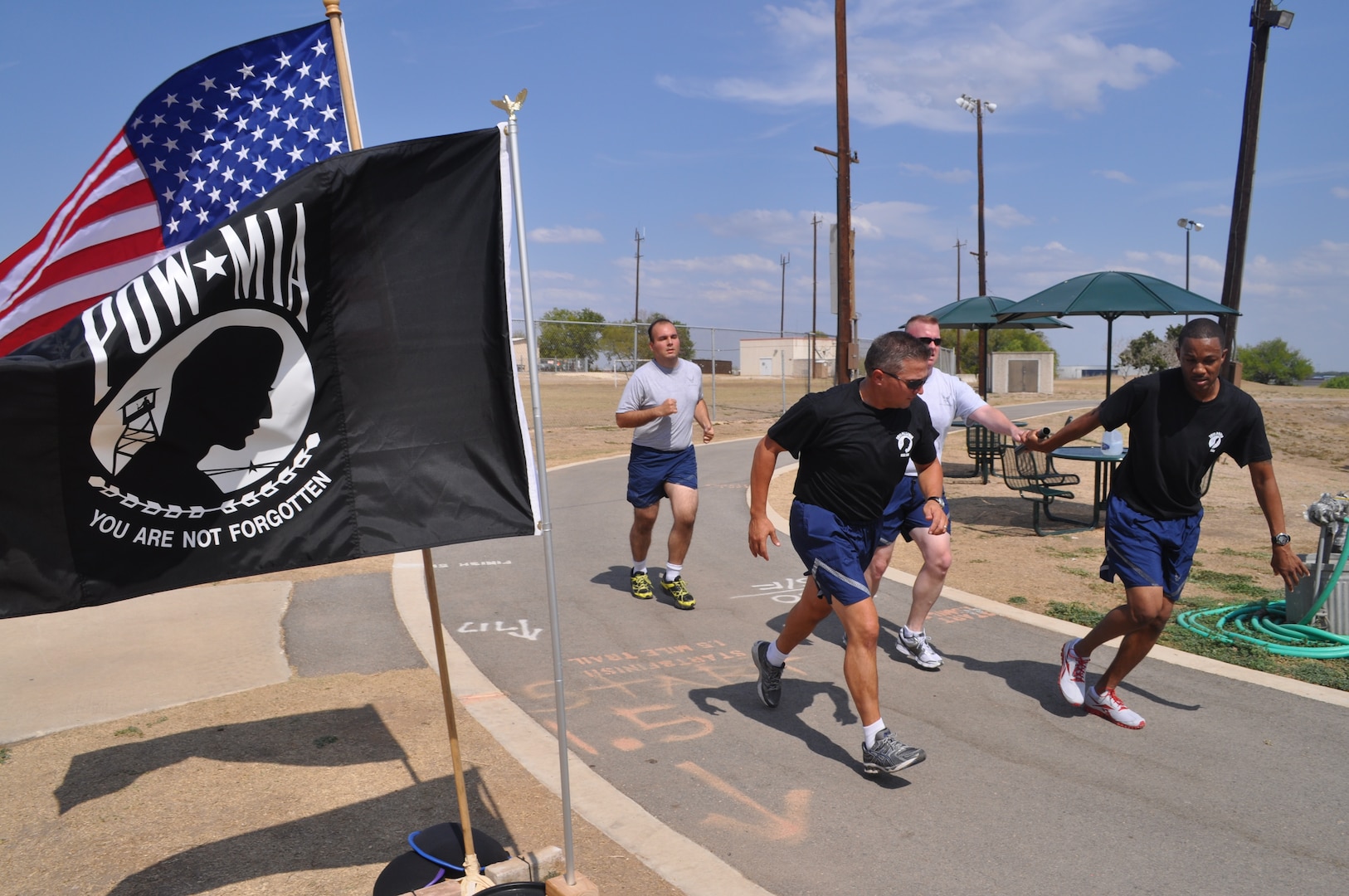 Technical Sgt. Gary Harris, a 24th Air Force personnelist, hands off the baton to Maj. James Hale, 26th Network Operations Group, during the 24-hour POW/MIA Vigil Run at the Gillum Fitness Center track, Lackland Air Force Base, Texas, Sept. 15. Volunteers also read aloud the names of American military members listed as prisoners of war or missing in action. Cyberspace operators and support personnel from across 24th Air Force units participated in the Lackland Security Hill vigil. (U.S. Air Force photo by Tech. Sgt. Scott McNabb)
