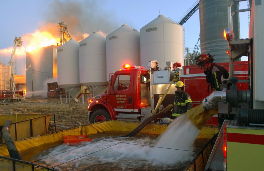 James Mozey, a firefighter from Grand Forks Air Force Base, N.D., begins draining 5,000 gallons of water from a base tender truck into a water reservoir to help battle a massive blaze in the Forest River (N.D.) Farmers Elevator on Sept. 13, 2011. The base personnel – along with firefighting personnel from other local towns – helped respond to the fire about 20 miles north of the base as part of a mutual aid agreement. (U.S. Air Force Photo/Tim Flack)
