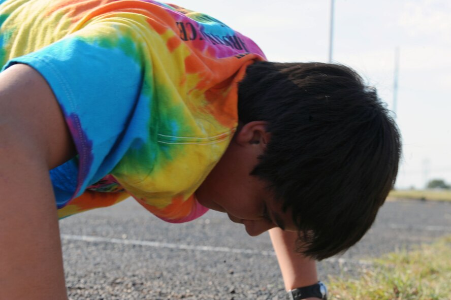 Daniel Guerra, 10th grader at The Academy of Technology, Engineering, Math and Science, Abilene, Texas, does push-ups Sept. 13, 2011, as part of Dyess Week. Dyess Week continues Dyess’ partnership with the Abilene community by supporting local schools’ fitness programs, educate the community on Dyess’ mission and raise awareness for the 64th anniversary of the Air Force’s birthday. (U.S. Air Force photo by Airman 1st Class Courtney Moses/Released) 