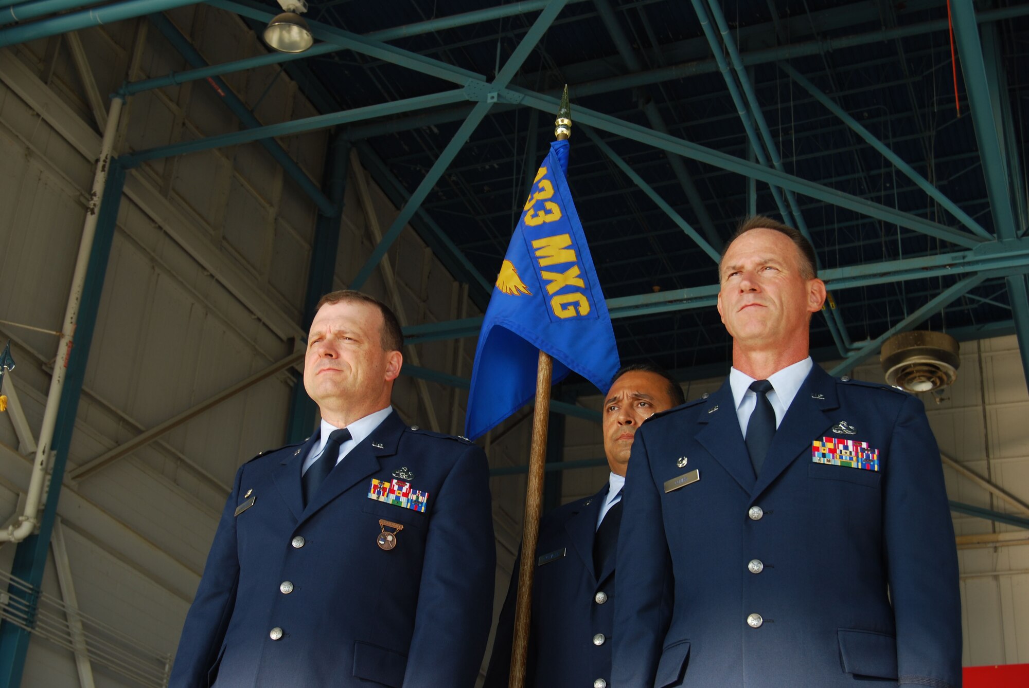 Col. Charles M. Combs, Right, will accept the guidon and take command of the 433rd Maintenance Group from Col. Craig S. Petersen, 433rd Mission Support Group commander. Chief Master Sgt. Gil Morales, 433rd Maintenance Squadron first sergeant, served as profer for the assumption of command held Sept. 11, 2011, at the 433rd Airlift Wing fuel cell at Lackland Air Force Base, Texas. . (U.S.Air Force Photo/Master Sgt. Collen McGee)