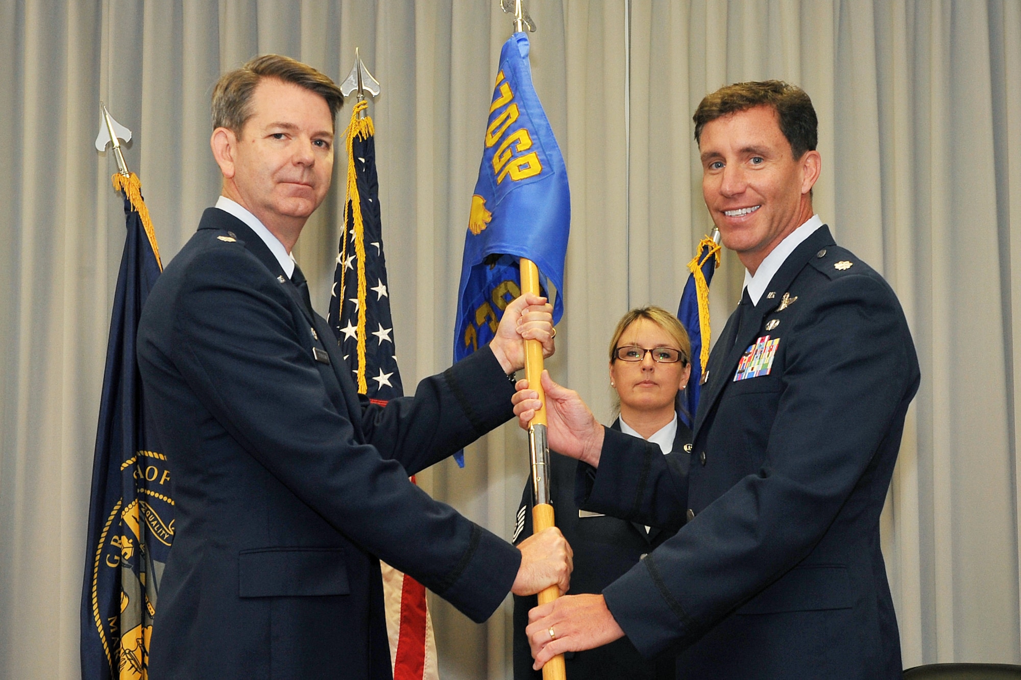 U.S. Air Force Col. James Stevenson, 170th Operations Group commander, passed the 238th Combat Training Squadron guidon to incoming commander U.S. Air Force Lt. Col. Mark Hopson during a change of command ceremony inside the 55th Operations Support Squadron auditorium at Offutt Air Force Base, Neb., Sept. 21. (U.S. Air Force photo by Charles Haymond/Released)