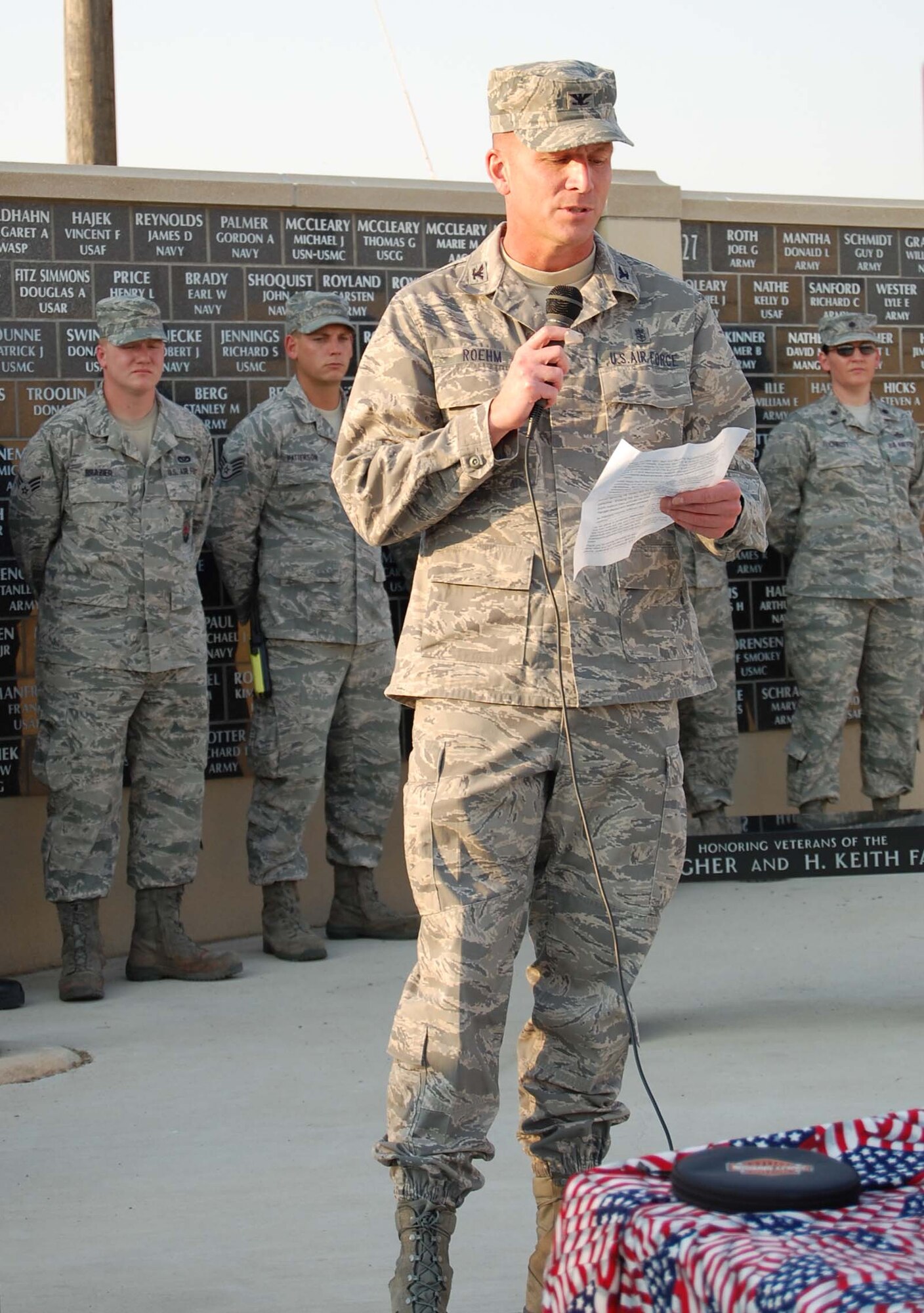 Col. Bruce Roehm, 341st Medical Group commander, shares his memories of 9/11 with the crowd as he delivers some remarks during the "Never Forget" ceremony at Veteran's Memorial Park. Members of Malmstrom's fire depart are in the background representing the military first responders. (U.S. Air Force photo/Valerie Mullett)