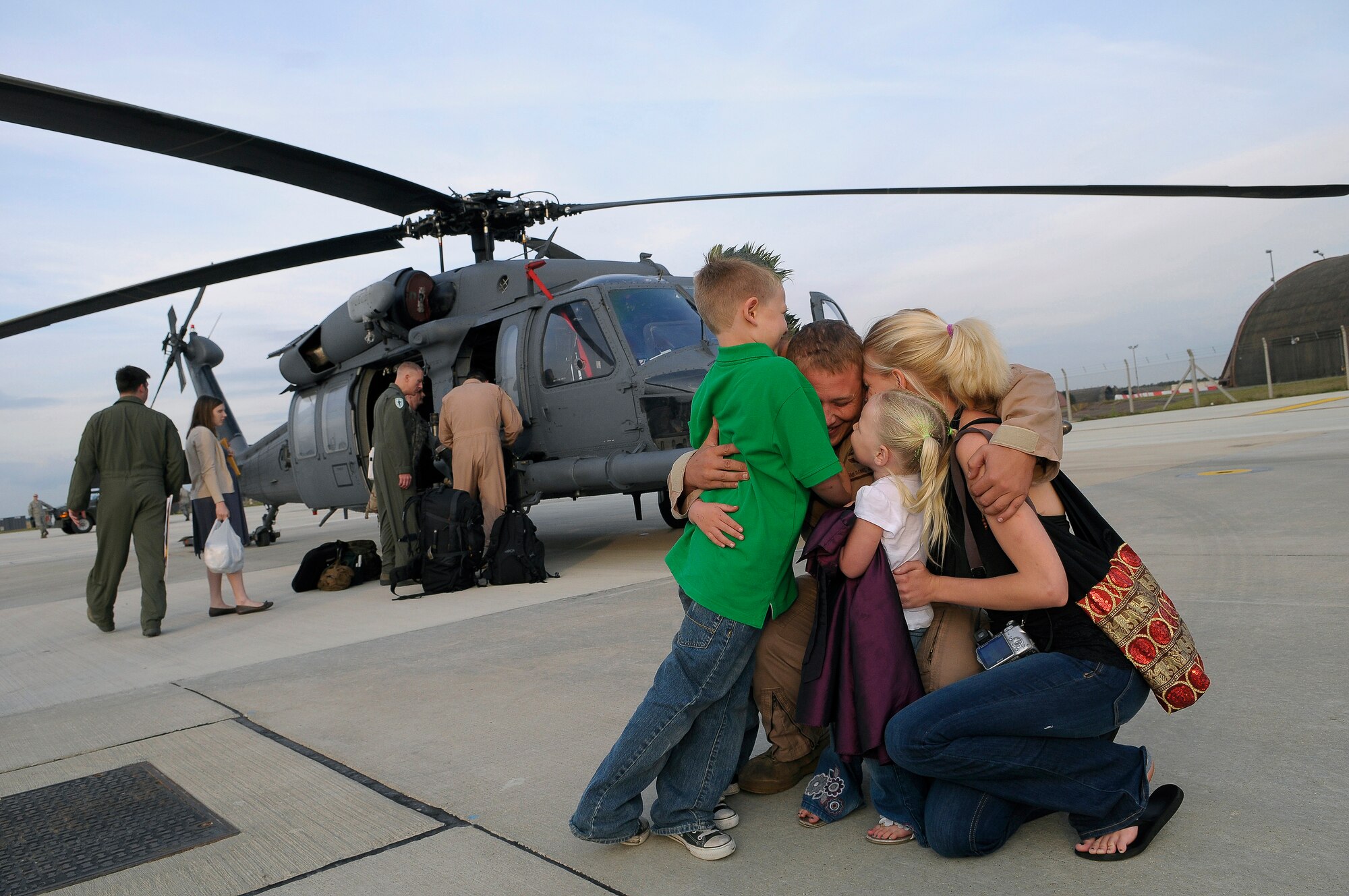 ROYAL AIR FORCE LAKENHEATH, England - Staff Sgt. Daniel Garrison, 56th Rescue Squadron Aerial Gunner receives a hug from his family, September 15, 2011. Approximately 60 members from the 56th Rescue Squadron and 748th Aircraft Maintenance Squadron returned home after back-to-back deployments lasting more than nine months in support of Operations Enduring Freedom, Odyssey Dawn and Unified Protector.  The 56th RQS  is a combat-ready search and rescue squadron of HH-60G Pave Hawk helicopters capable of executing all-weather search and rescue missions day or night in hostile environments in support of the United States and its allies. (U.S. Air Force photo by Staff Sgt. Connor Estes)