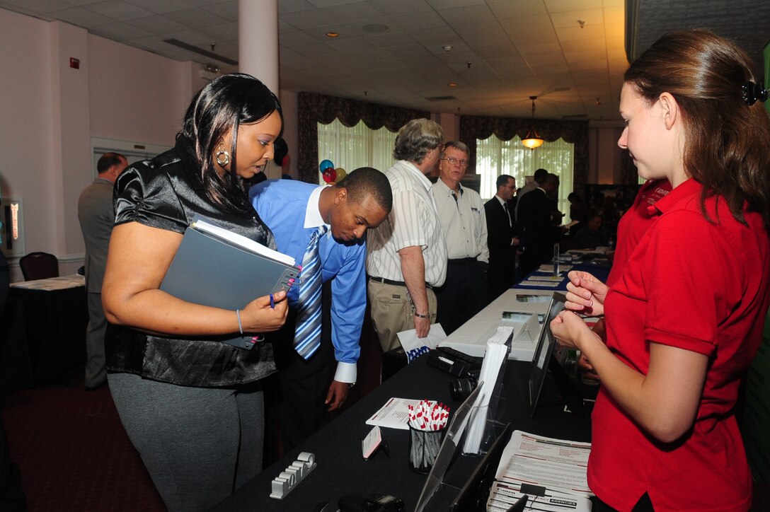 Sgt. Elton Gofoe, 510th Human Resources Company and his wife, Autumn, consider job opportunities during the job fair at the Fort Eustis Club Sept. 8.  The bi-annual event is held for military and civilians to meet face-to-face with possible employers for a smoother transition during the interview process. (U.S. Air Force photo by Staff Sgt. Ashley Hawkins/RELEASED)