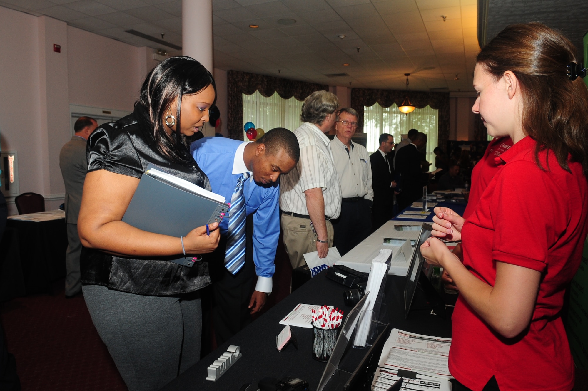Sgt. Elton Gofoe, 510th Human Resources Company and his wife, Autumn, consider job opportunities during the job fair at the Fort Eustis Club Sept. 8.  The bi-annual event is held for military and civilians to meet face-to-face with possible employers for a smoother transition during the interview process. (U.S. Air Force photo by Staff Sgt. Ashley Hawkins/RELEASED)