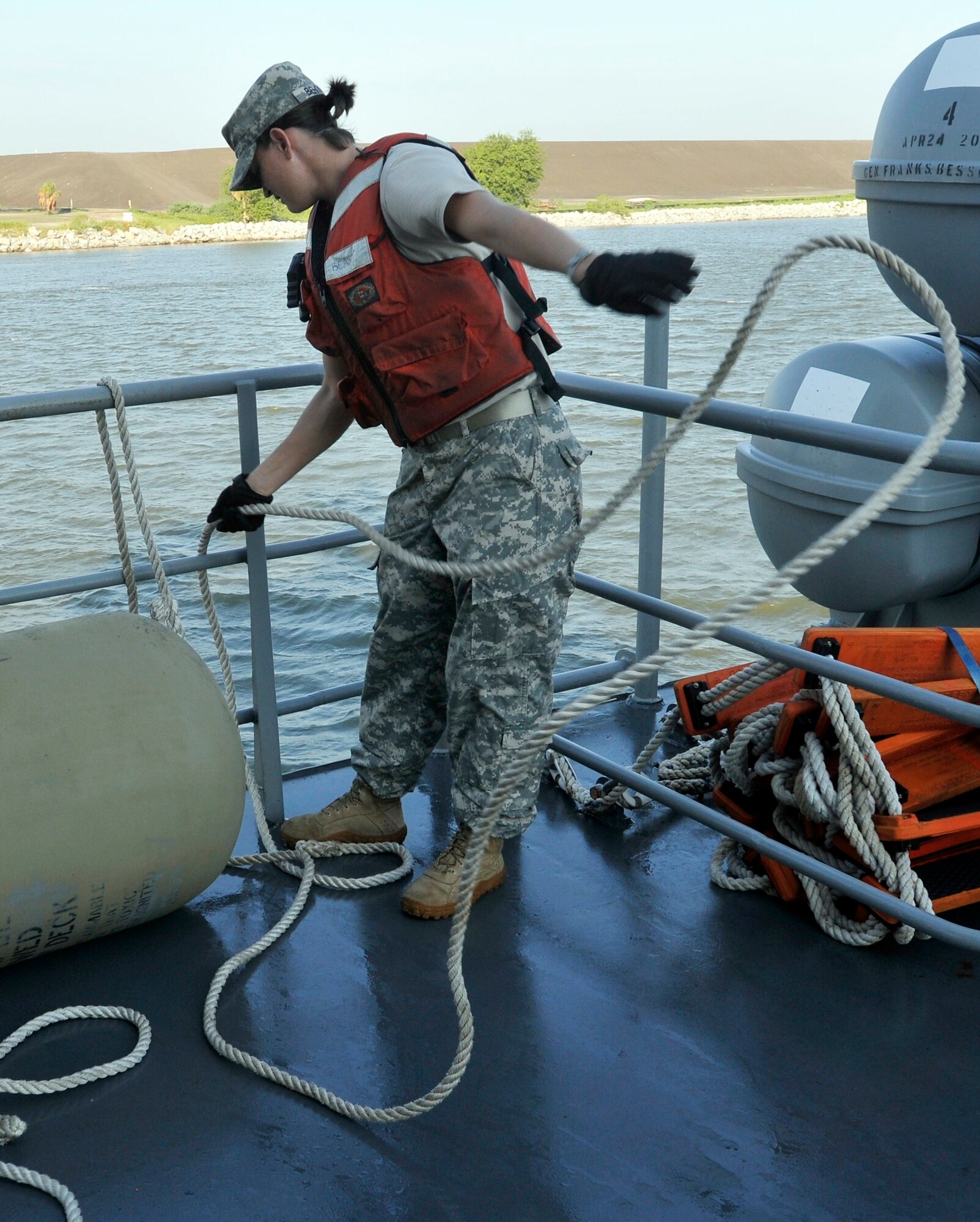 Spc. Christina Behymer, Army watercraft operator, 335th Transportation Detachment, “First and Finest,” 24th Transportation Battalion, 7th Sustainment Brigade, handles the lines holding a vessel bumper on board the Logistic Support Vessel-1 as it sails the Savannah River Aug. 15. (U.S. Army photo by Sgt. 1st Class Kelly Jo Bridgwater/RELEASED)