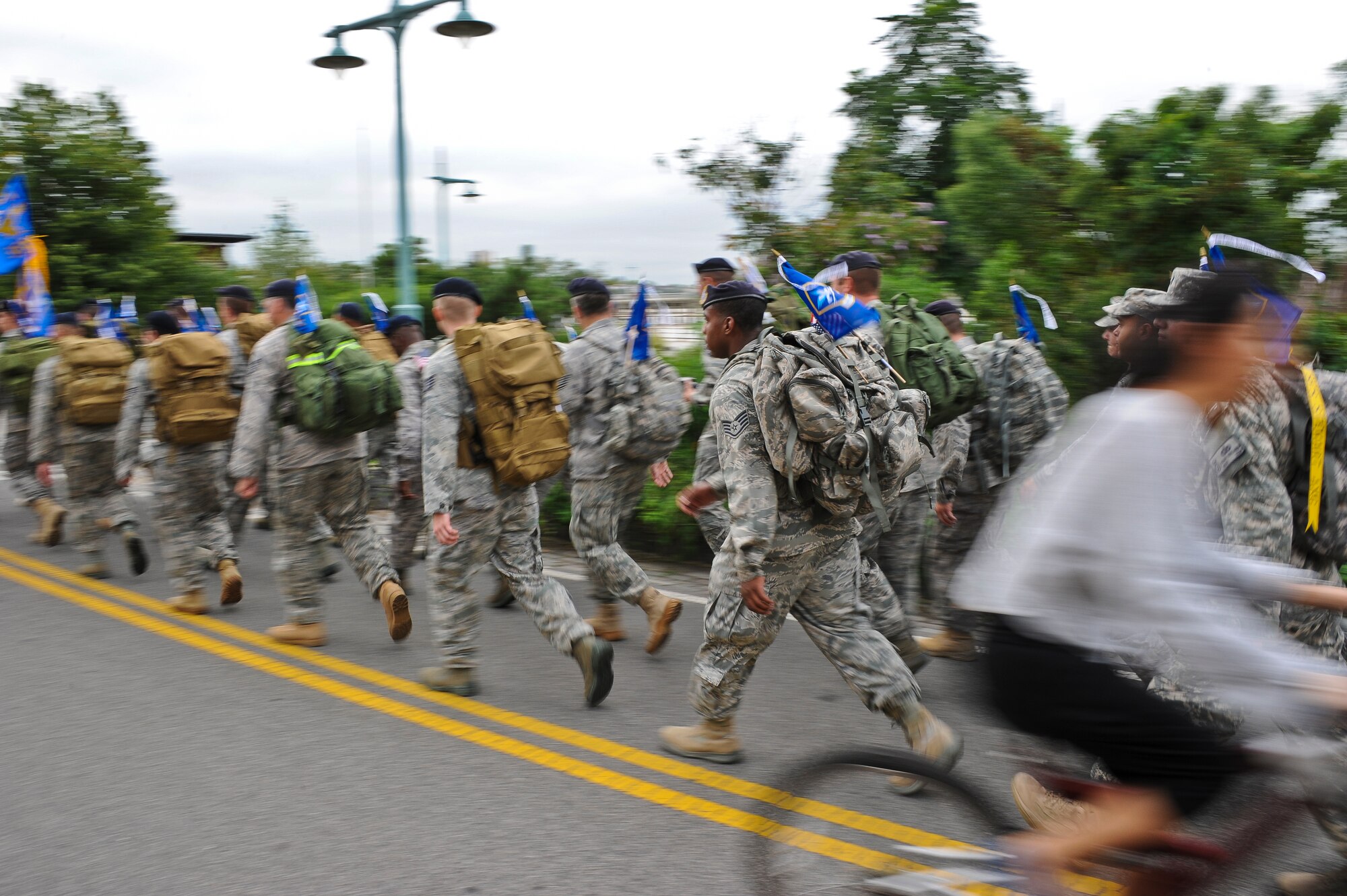 Joint Base McGuire-Dix-Lakehurst security forces members pass by bikers and joggers in New York City, N.Y. Sept. 11 as they complete the final leg of the Air Force 9/11 Ruck March to Remember. The ruck march started at Joint Base San Antonio, Texas July 17 and was completed with the help of 23 units carrying the guidon up to New York City. The security forces members marched into Battery Park where 2,976 flags stood in honor of each person who died on 9/11. (U.S. Air Force photo by Airman 1st Class Dennis Sloan/Released)