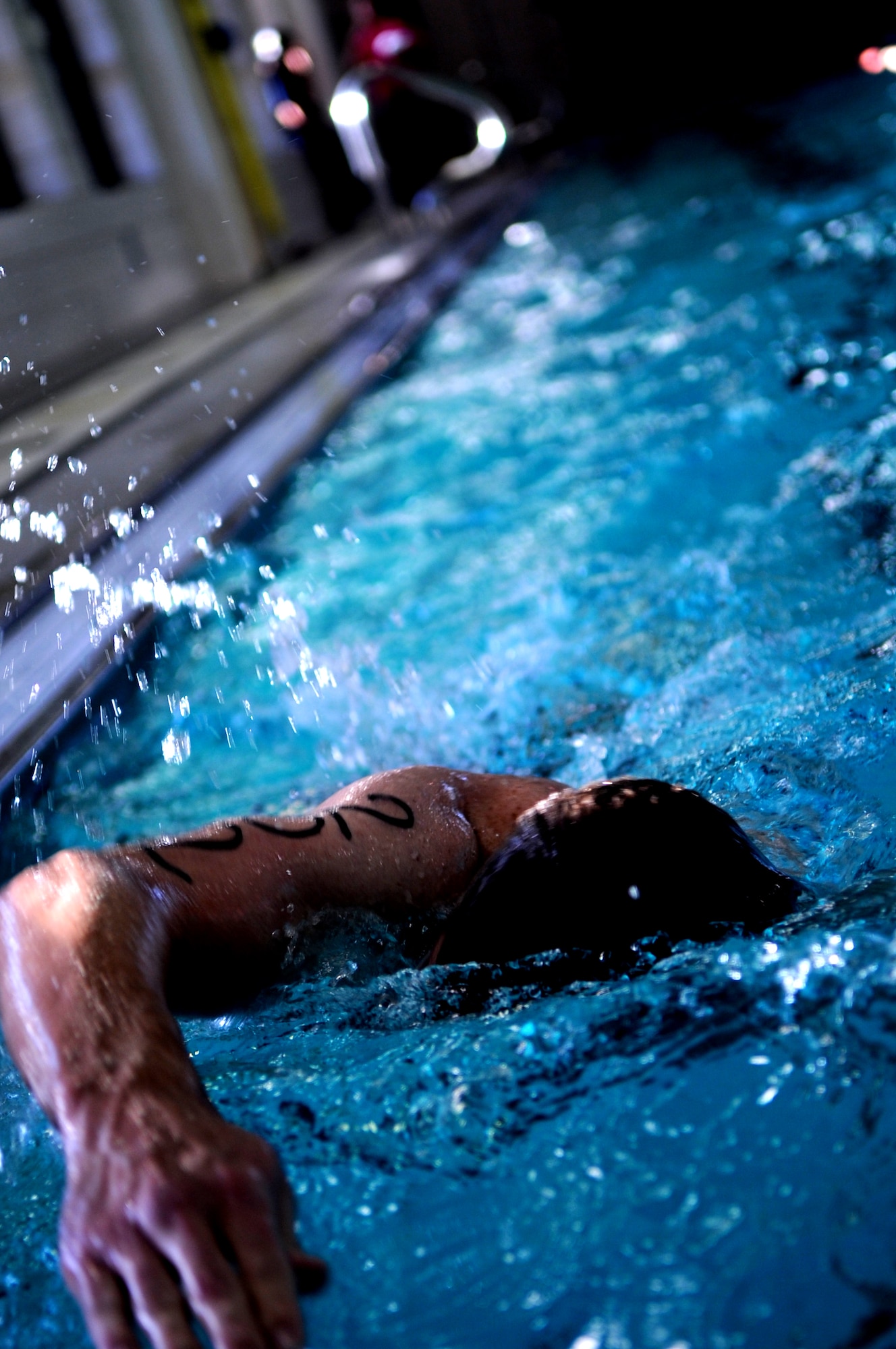 Capt. Andrew Stevens, 319th Medical Group, makes a reach at the end of the pool before beginning another lap in the Grand Forks Air Force Base gym pool Sept. 10. The swimming pool on GFAFB is indoors with areas designated for lap swim and recreational swimming along with a spacious pool-side lounge area with comfortable seating. (U.S. Air Force photo/Senior Airman Amanda N. Stencil)