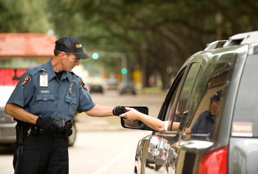 Peter Sheerin, a Pinkerton security guard, checks a driver's identification at the west gate on Barksdale Air Force Base, La., Sept. 15. Beginning Sept. 16, everyone wishing to gain access to the installation between the hours of 10 p.m. and 6 a.m. Friday and Saturday must have a valid Department of Defense ID or a Barksdale visitor pass. (U.S. Air Force photo/Senior Airman Chad Warren)(RELEASED)