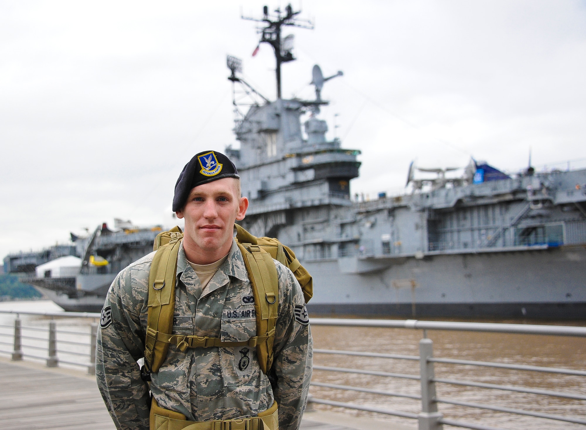 Staff Sgt. Steven Barber, 621st Contingency Response Wings Security Forces Raven, stands with his back to the Intrepid Sea, Air and Space Museum in New York City, N.Y. Sept. 11 moments before starting the last leg of the Air Force 9/11 Ruck March to Remember. Barber and fellow security forces members marched from the intrepid to Battery Park, where 2,796 flags covered the area to honor each person who died on 9/11. (U.S. Air Force photo by Airman 1st Class Dennis Sloan/Released)