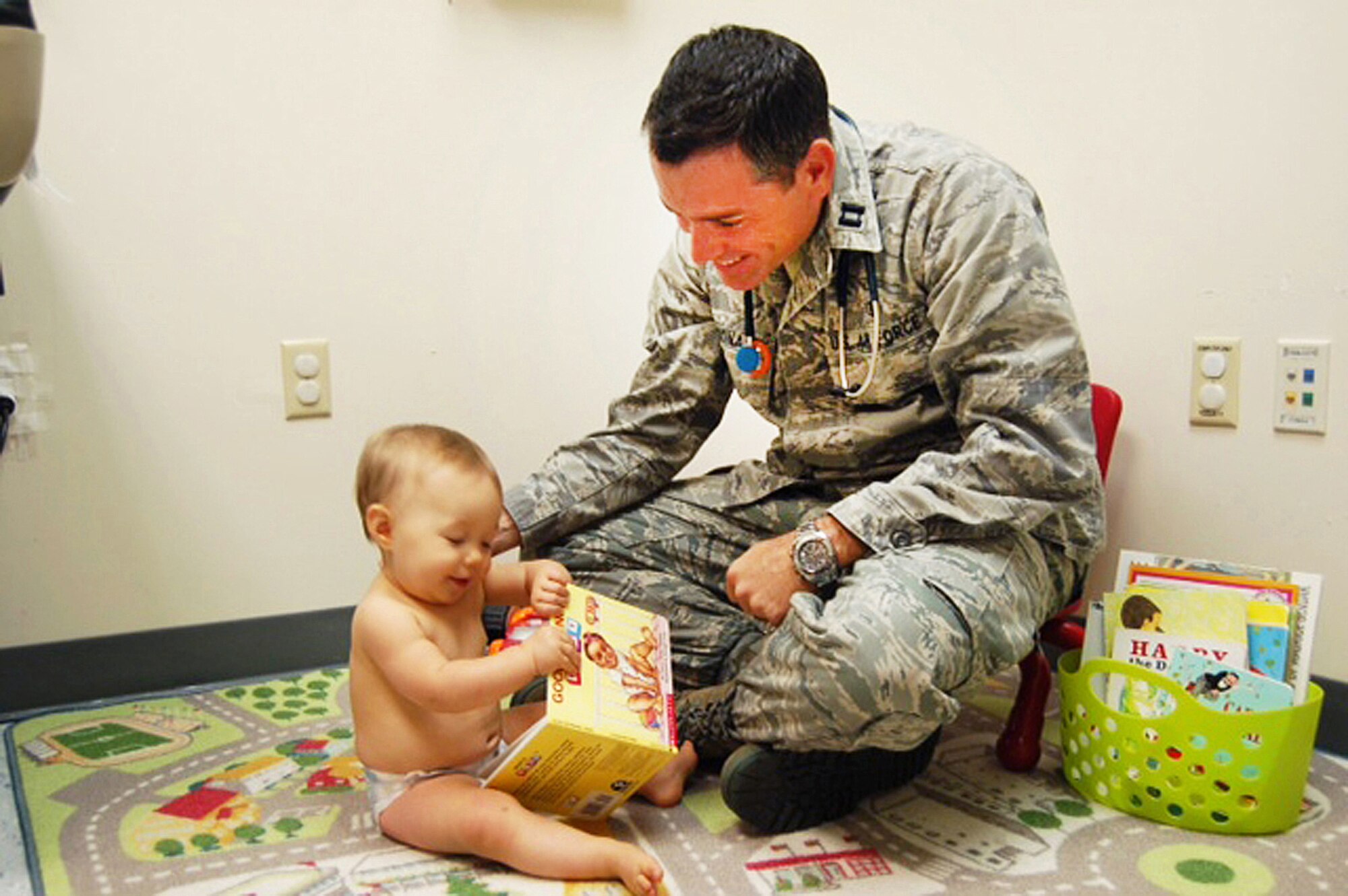 Elenore Beth Zimmerman, 10-month-old daughter of 2nd Lt Nicolas and Amber Zimmerman, gets a checkup and a story from with Capt. (Dr.) Curtis McDonald,  base pediatrician. Courtesy photo