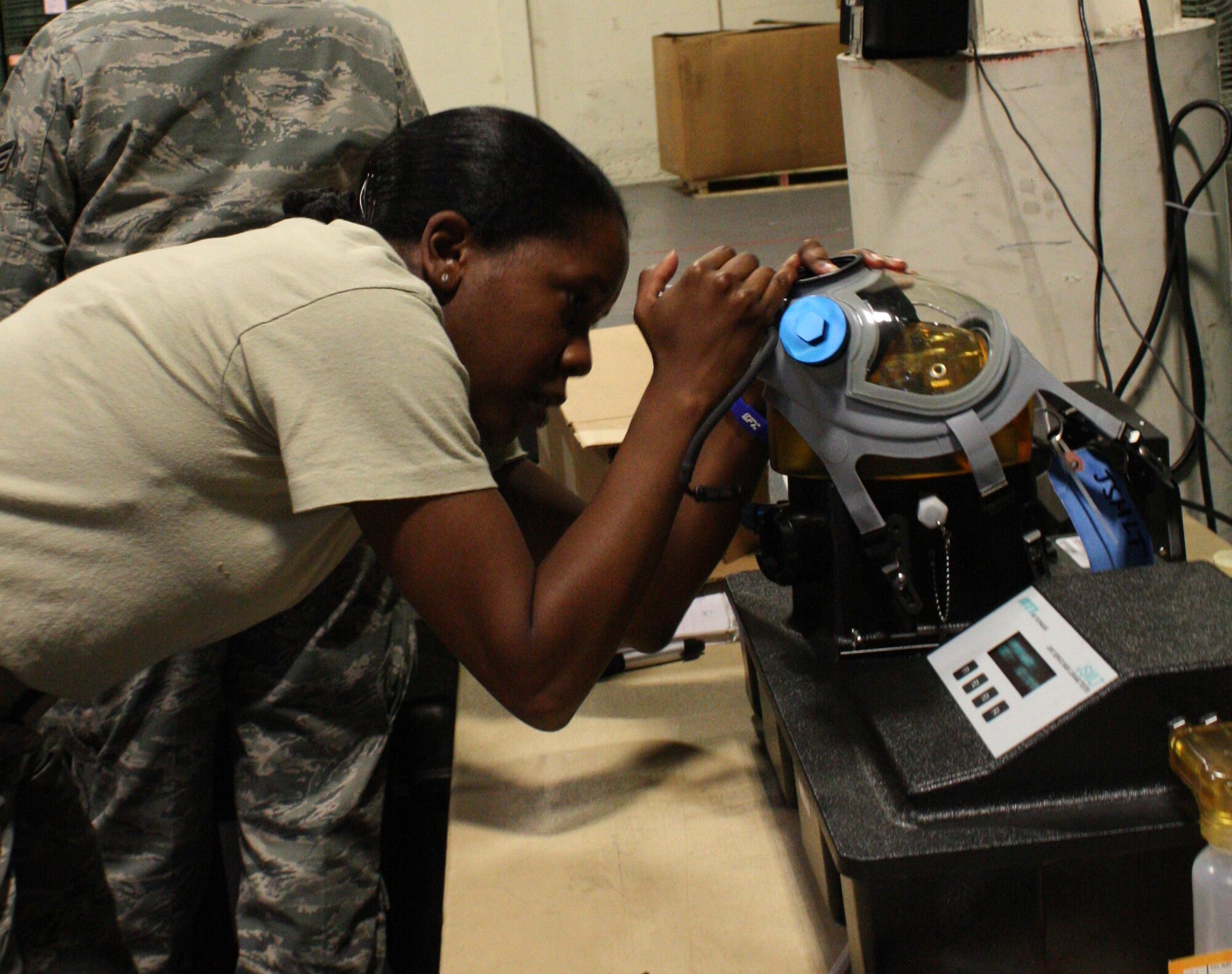 TRAVIS AIR FORCE BASE, Calif. -- Airman 1st Class Alivia Hampton, 349th Logistics Readiness Squadron, checks the status of a gas mask test during a routine inspection here on August 5, 2011. (U.S. Air Force photo by Senior Airman Amelia Leonard)