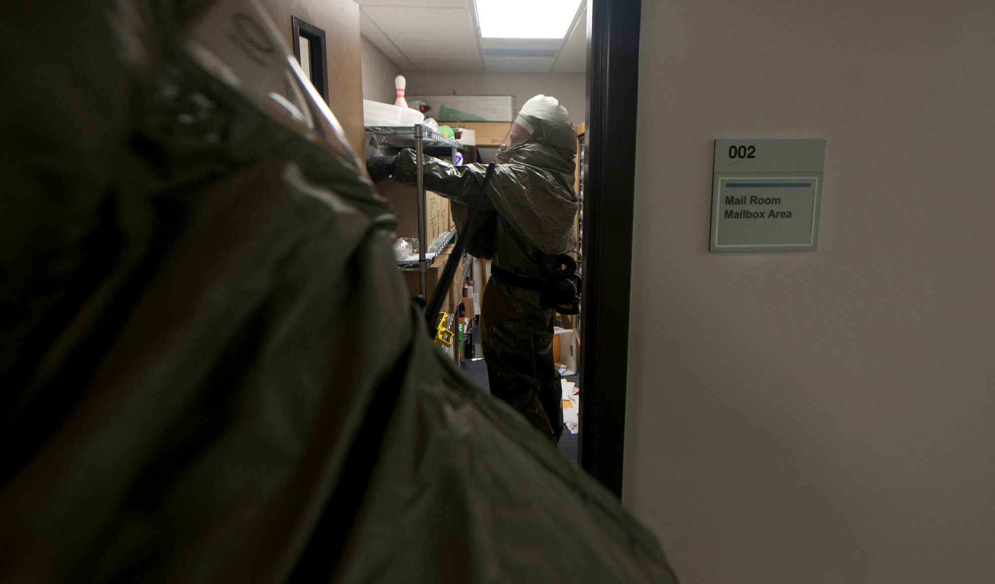 U.S. Air Force Airmen from the 23rd Aerospace Medical Squadron bioenvironmental engineering flight search a mail room for contaminated material during a training exercise at Moody Air Force Base, Ga., Sept. 14, 2011. The Airmen were tasked to locate the hazardous material, test it at the field site and send the contaminants to the base lab. (U.S. Air Force photo by Airman 1st Class Joshua Green)
